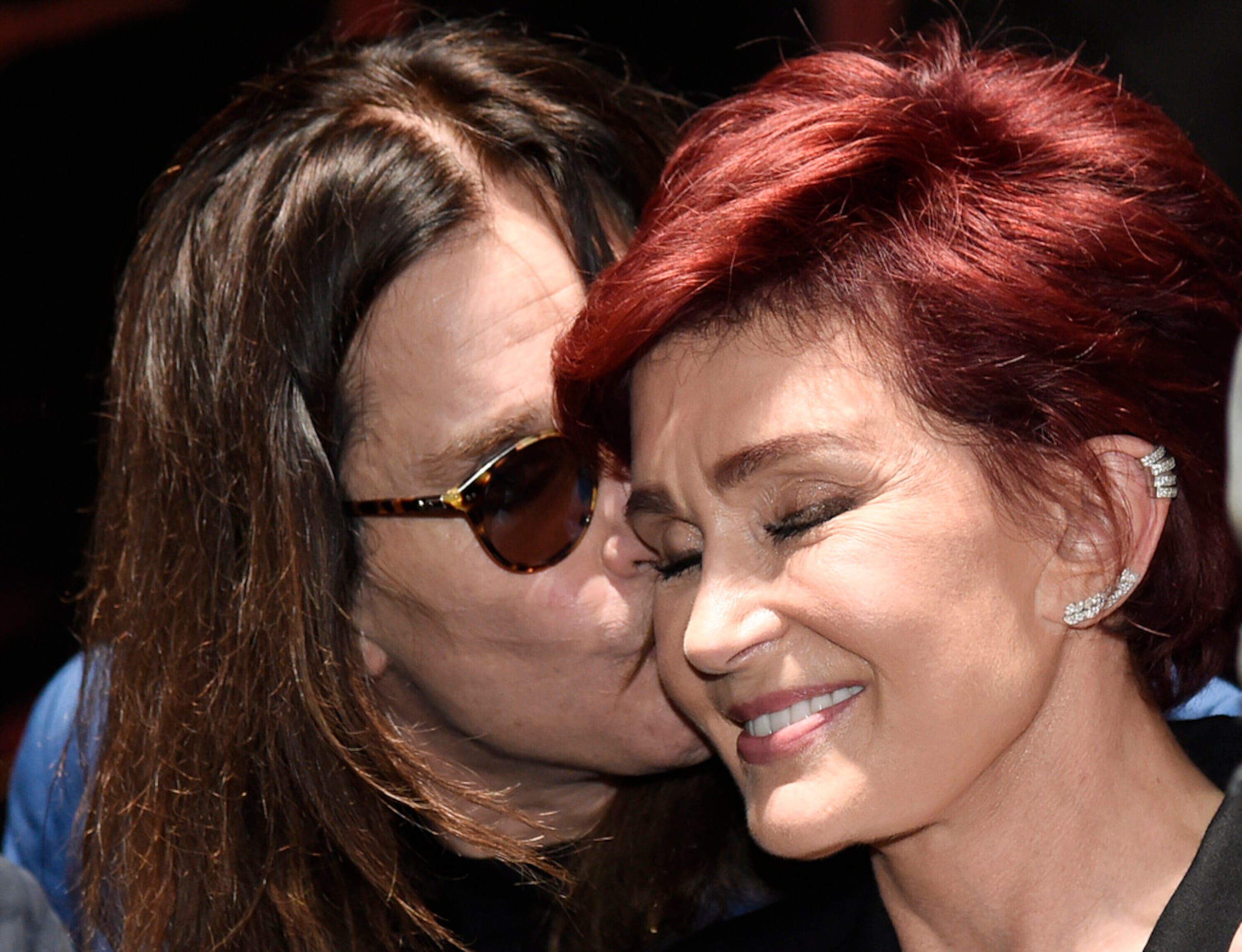Ozzy Osbourne besa a su esposa Sharon durante la conferencia de prensa "Ozzfest Meets Knotfest" en el Hollywood Palladium, el 12 de mayo de 2016, en Los Ángeles. (Foto Chris Pizzello/Invision/AP, archivo)