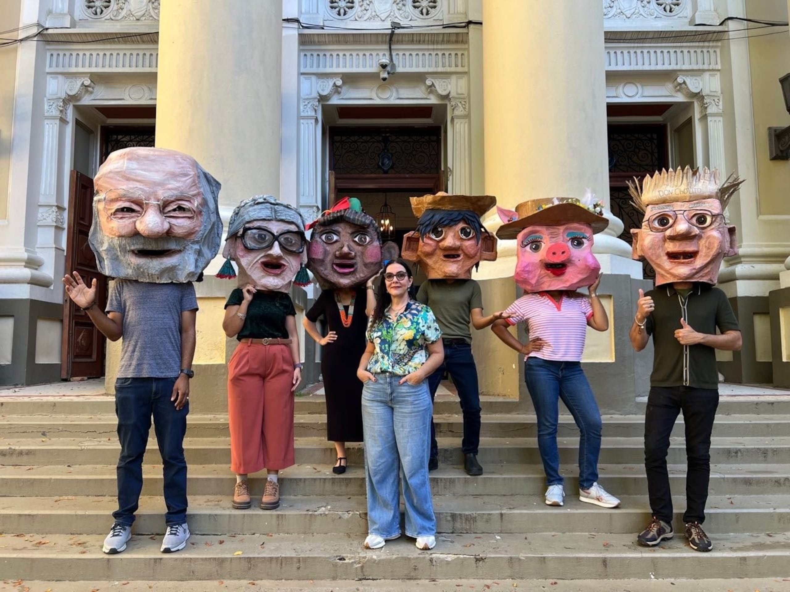 La profesora Sonia Iris Kercadó Rivera con los cabezudos de Jacobo Morales, confeccionado hace más de un año por otro grupo de jóvenes; Felisa Rincón de Gautier, la jibarita, Juan Bobo y la puerca, y Don Cholito.