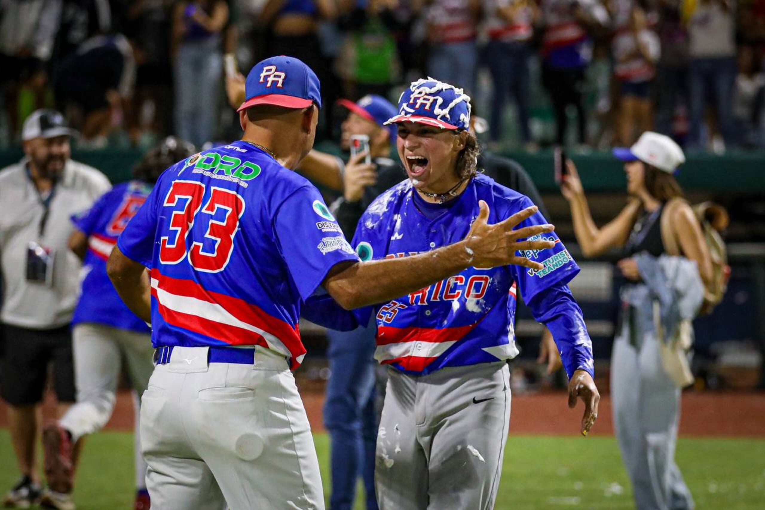 Carlos Rodríguez (derecha) celebra al concluir el partido a favor de Puerto Rico.