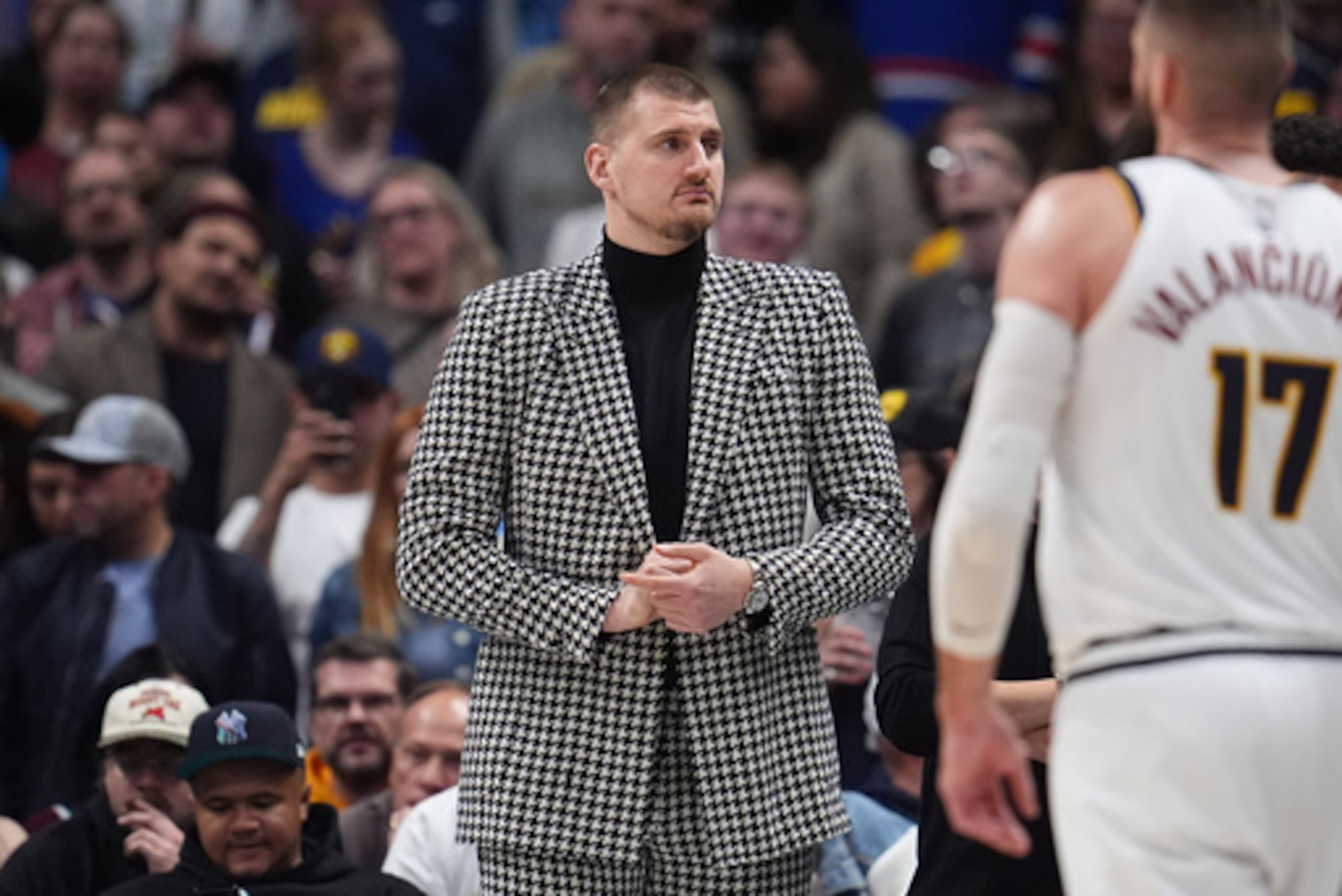 El pívot lesionado de los Denver Nuggets Nikola Jokić mira desde la línea de fondo en la segunda mitad de un partido de baloncesto de la NBA contra los Brooklyn Nets el jueves 29 de enero de 2026, en Denver. (AP Photo/David Zalubowski)
