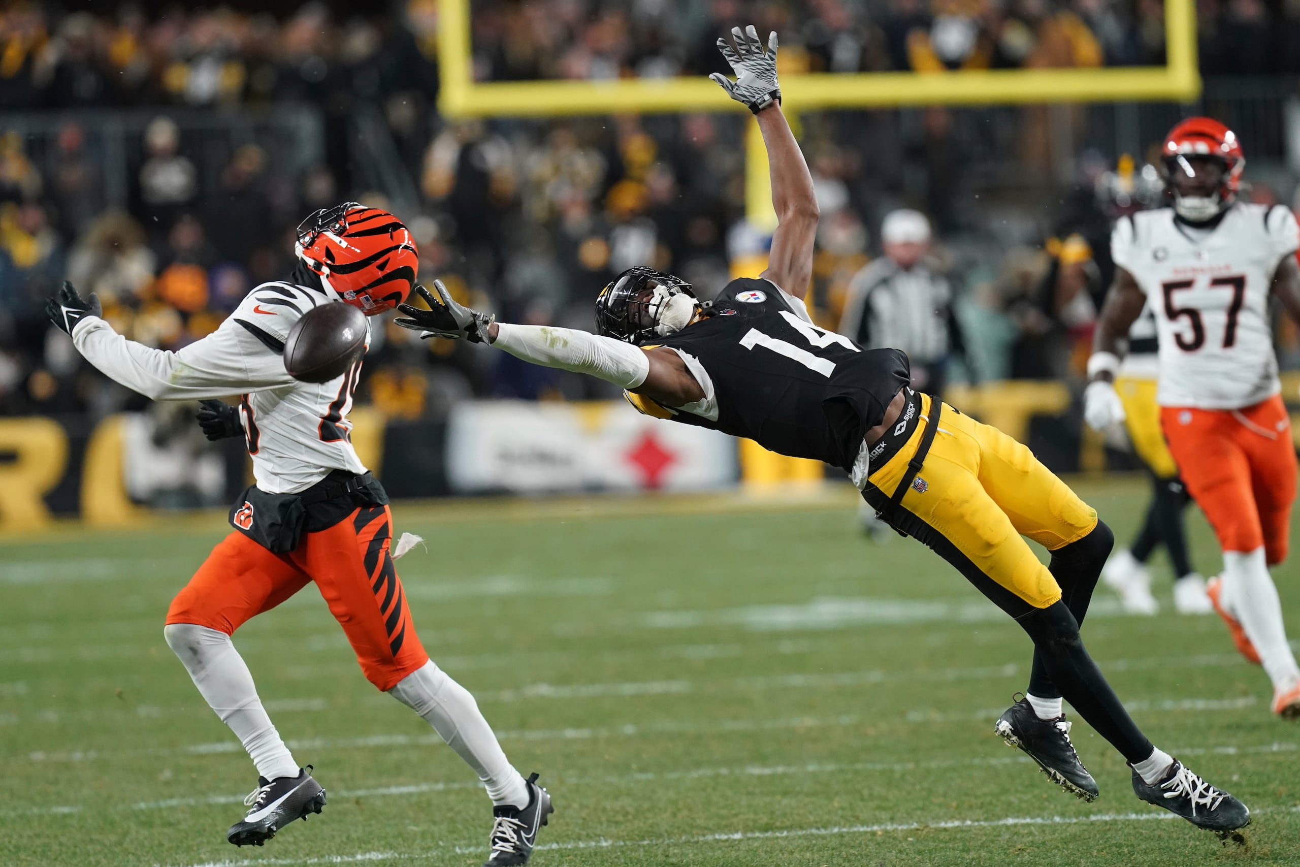 George Pickens (14), wide receiver de los Steelers de Pittsburgh, no puede recibir un pase frente a los Bengals, con la cobertura de Josh Newton (28), de Cincinnati, durante la segunda mitad del partido de la NFL el sábado 4 de enero de 2025. Los Bengals ganaron 19-17. (AP Foto/Matt Freed)