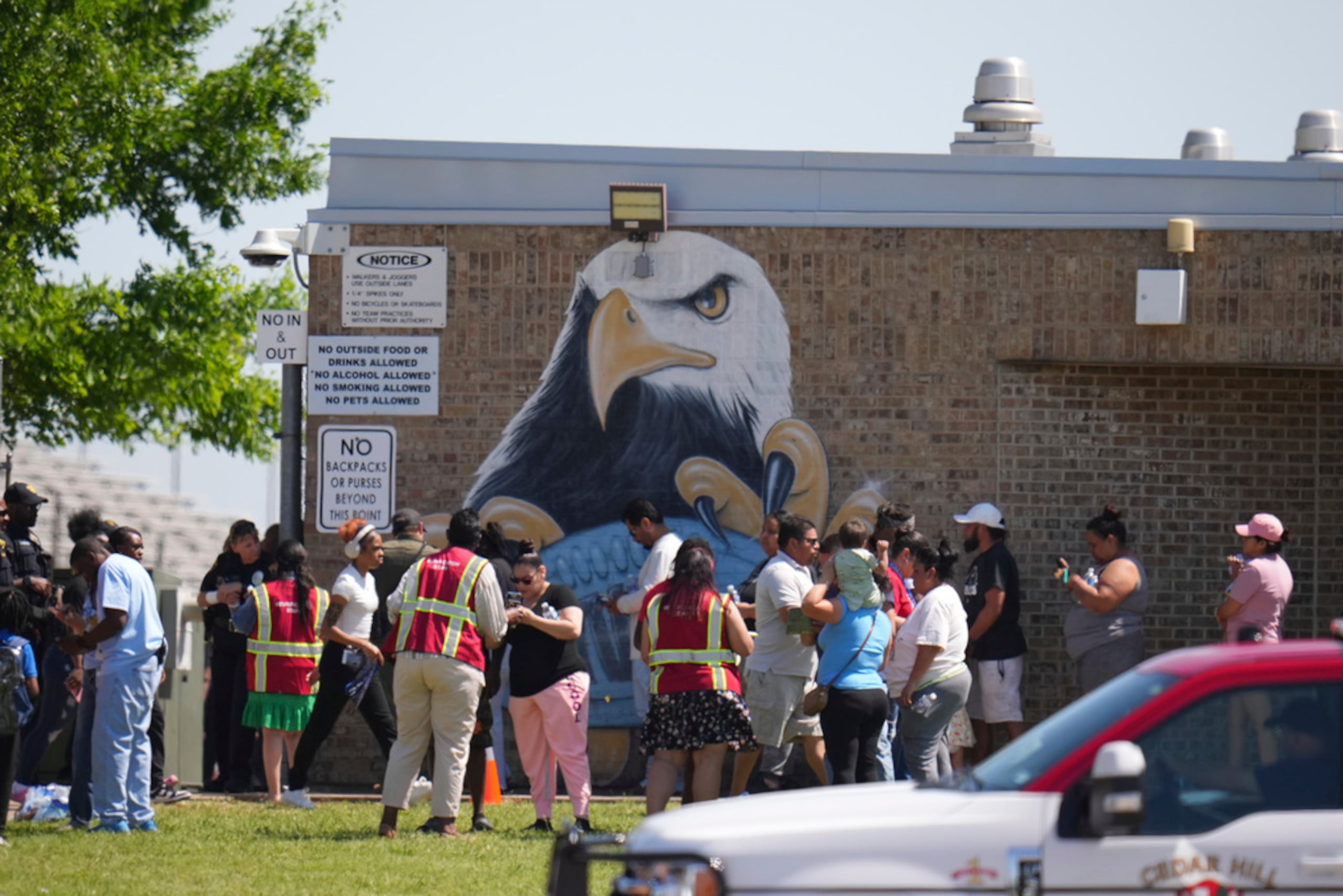 Padres se registran para recoger a sus hijos en la escuela superior Wilmer-Hutchins, donde la policía respondió a reportes de un tiroteo en Dallas, Texas, el martes.