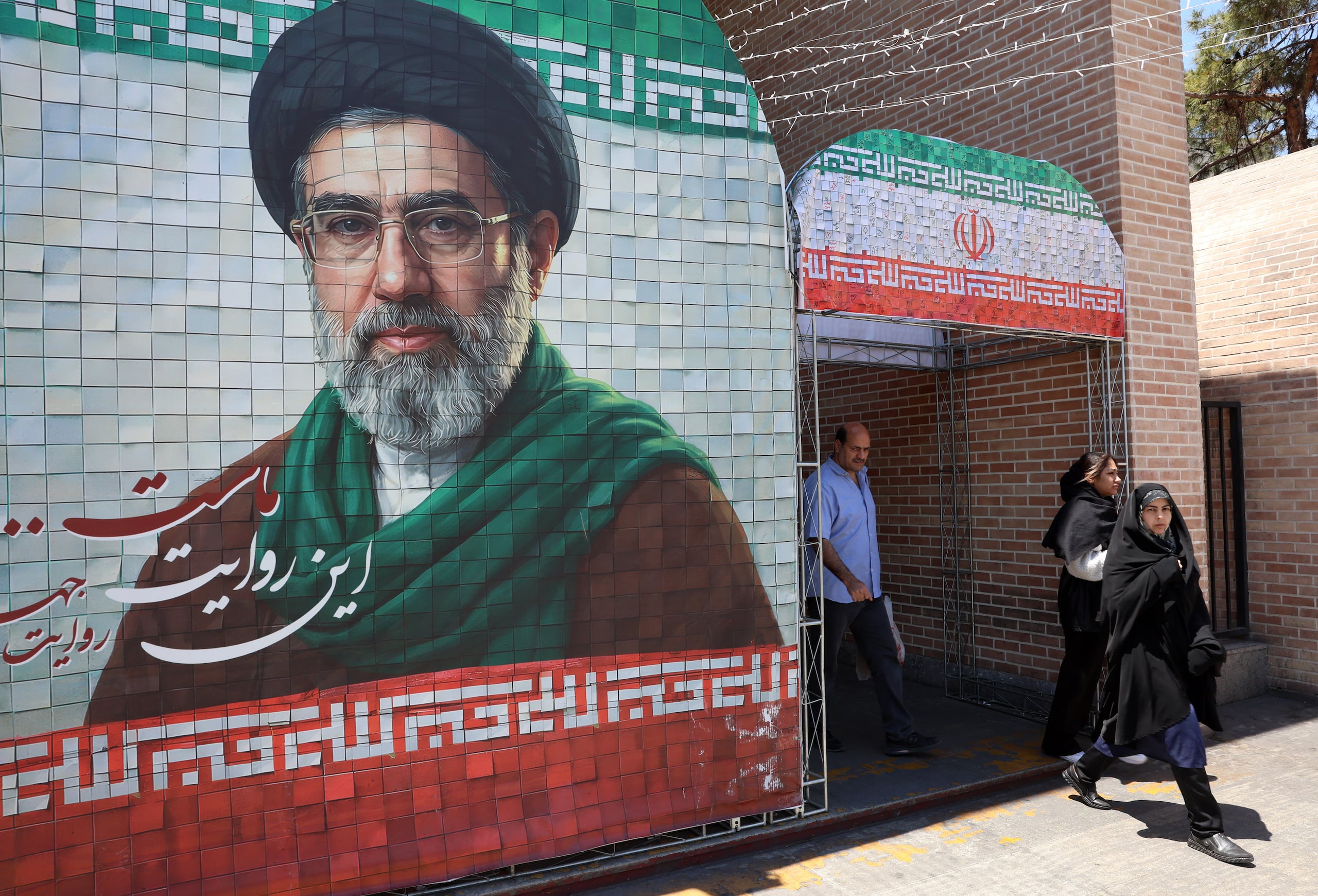 Iraníes pasan junto a una imagen del líder supremo iraní, el ayatolá Mojtaba Khamenei, en una calle de Teherán, Irán.