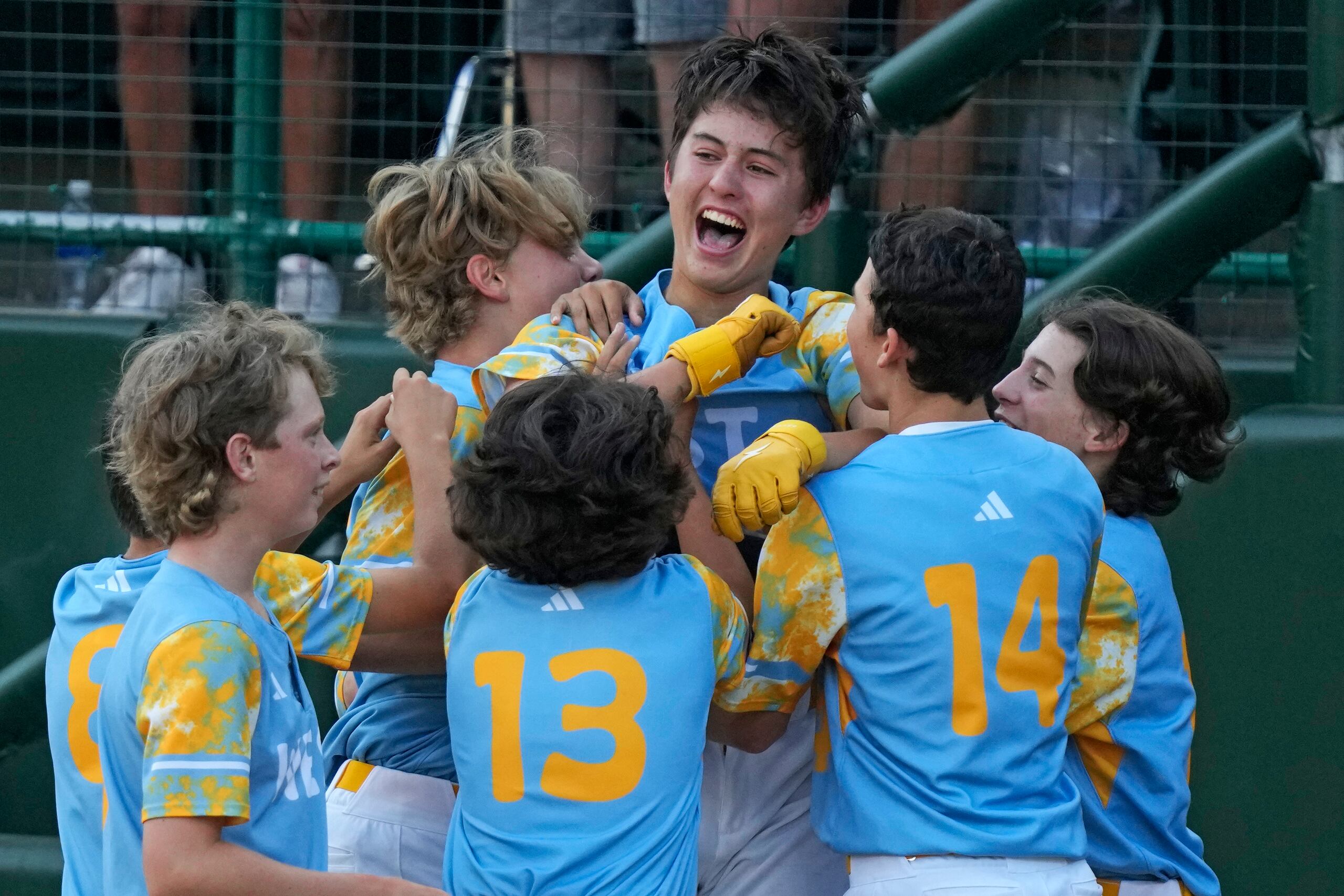 Louis Lappe, centro, de El Segundo, California, celebra con sus compañeros de equipo después de batear un cuadrangular con el que su equipo dejó tendido a Curazao durante la sexta entrada en la Serie Mundial de Pequeñas Ligas, en South Williamsport, Pennsylvania, el domingo 27 de agosto de 2023. California ganó 6-5. (AP Foto/Gene J. Puskar)