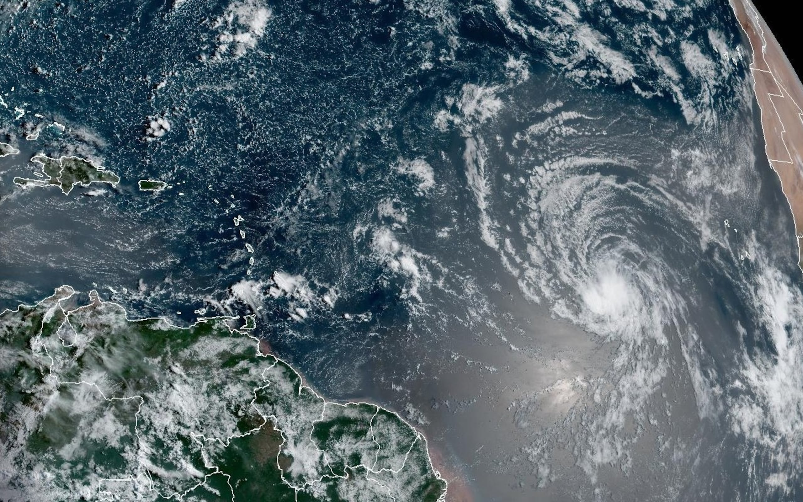 La onda tropical Invest 96L se observa a la derecha de esta imagen de satélite, tomada este jueves.