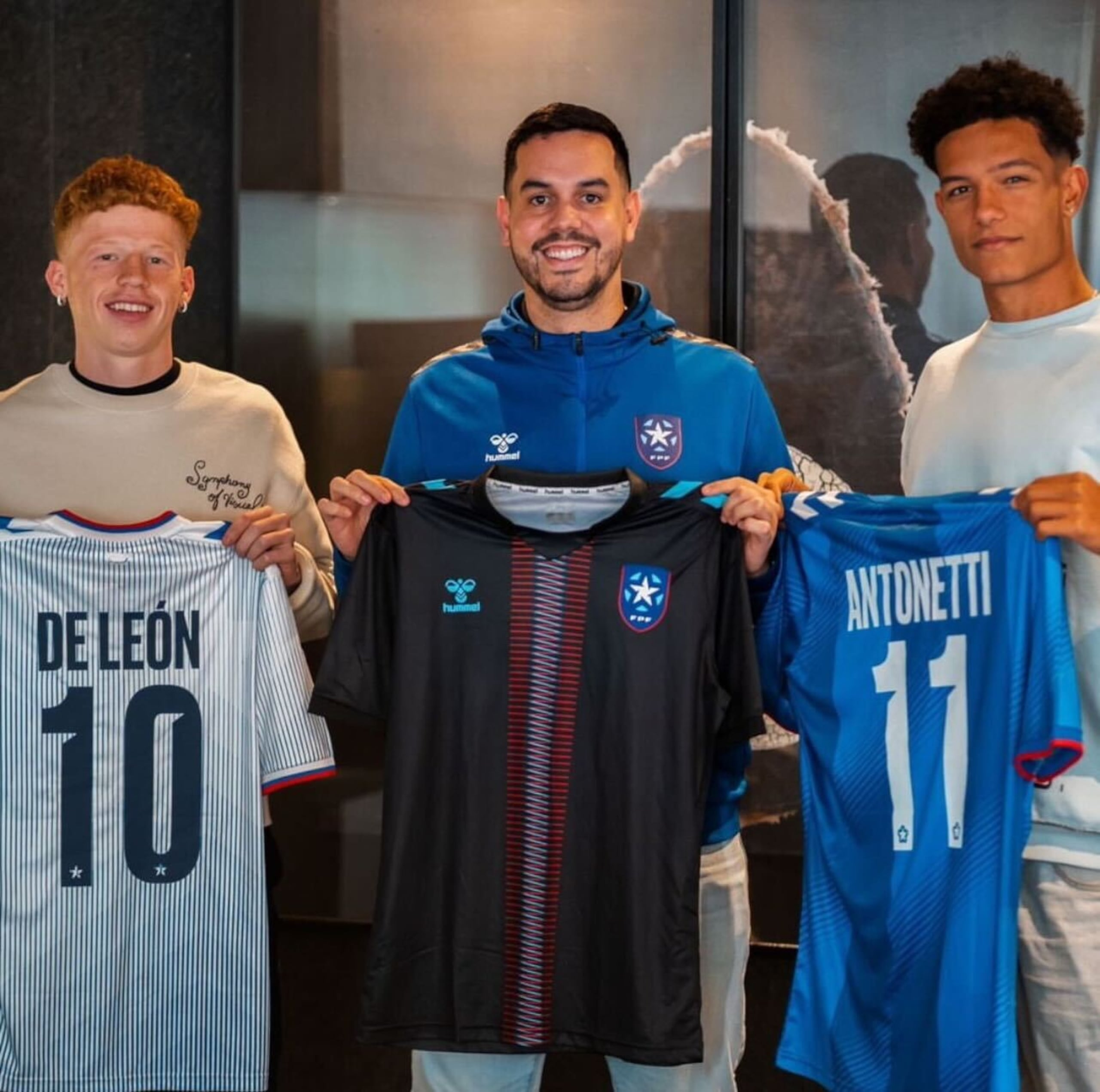 Jeremy De León (izquierda); el presidente de la Federación Puertorriqueña de Fútbol, Iván Rivera; y Leandro Antoneiti posan con las camisetas de la Selección Nacional.