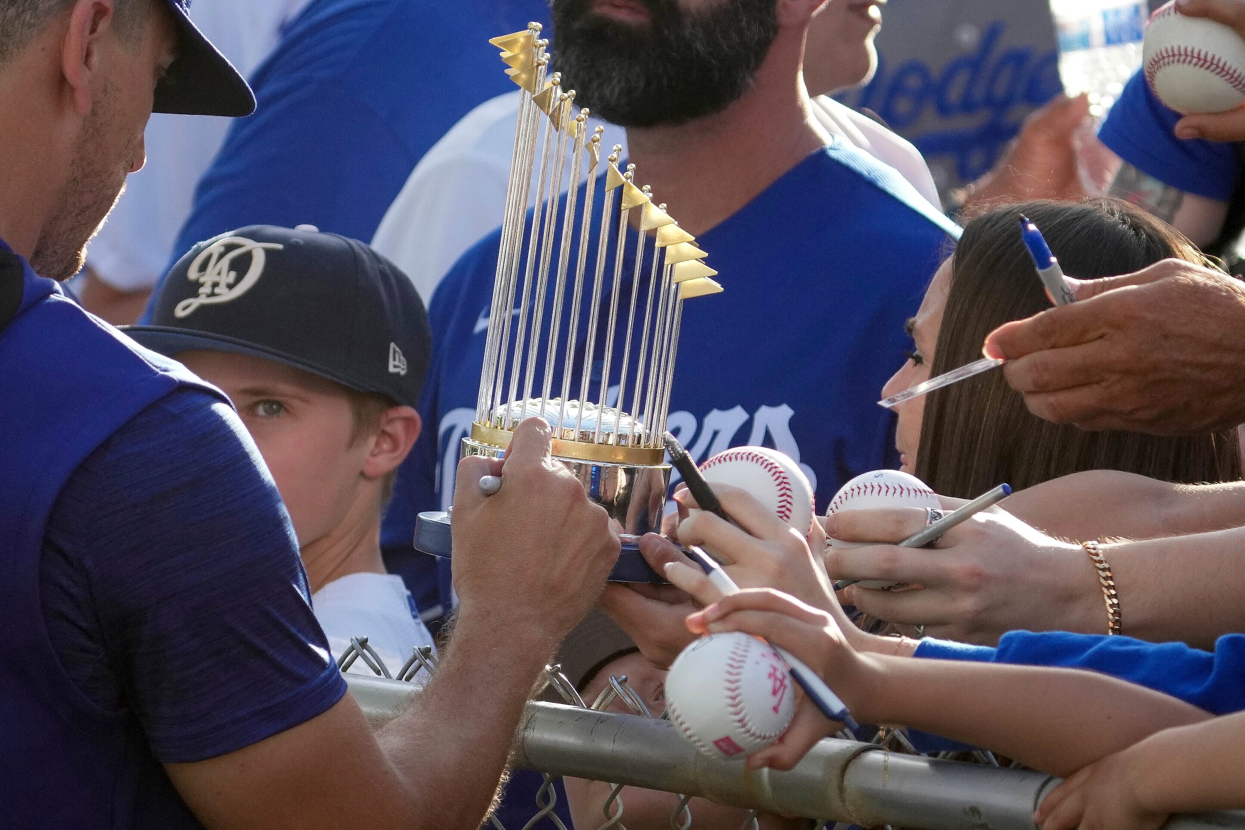 Un jugador de los Dodgers de Los Ángeles firma un trofeo miniatura de la Serie Mundial durante los entrenamientos de primavera, el 28 de febrero de 2025, en Phoenix.