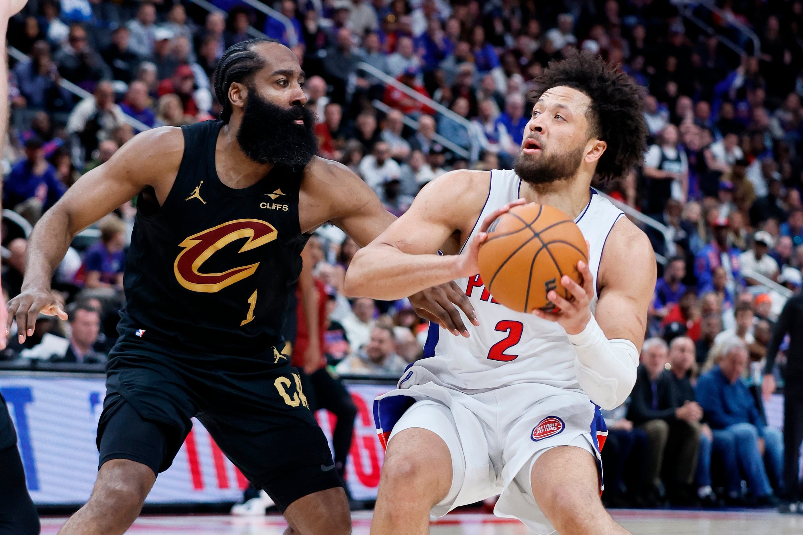 Cade Cunningham, de los Pistons de Detroit, busca lanzar el balón ante la defensa de James Harden.