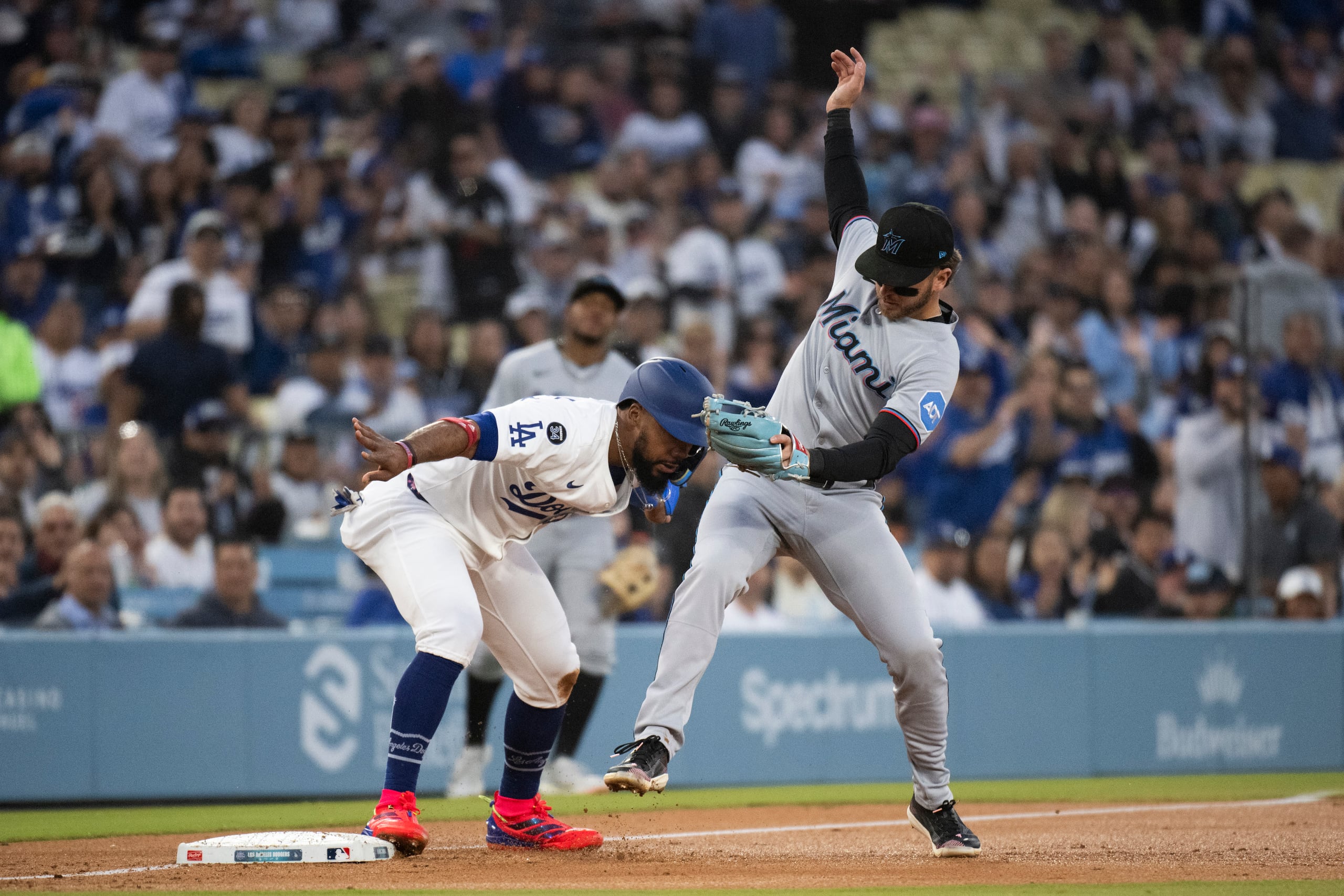 El dominicano Teoscar Hernández, de los Dodgers de Los Ángeles, llega quieto a la antesala pese a un tiro hacia Connor Norby, de los Marlins de Miami.
