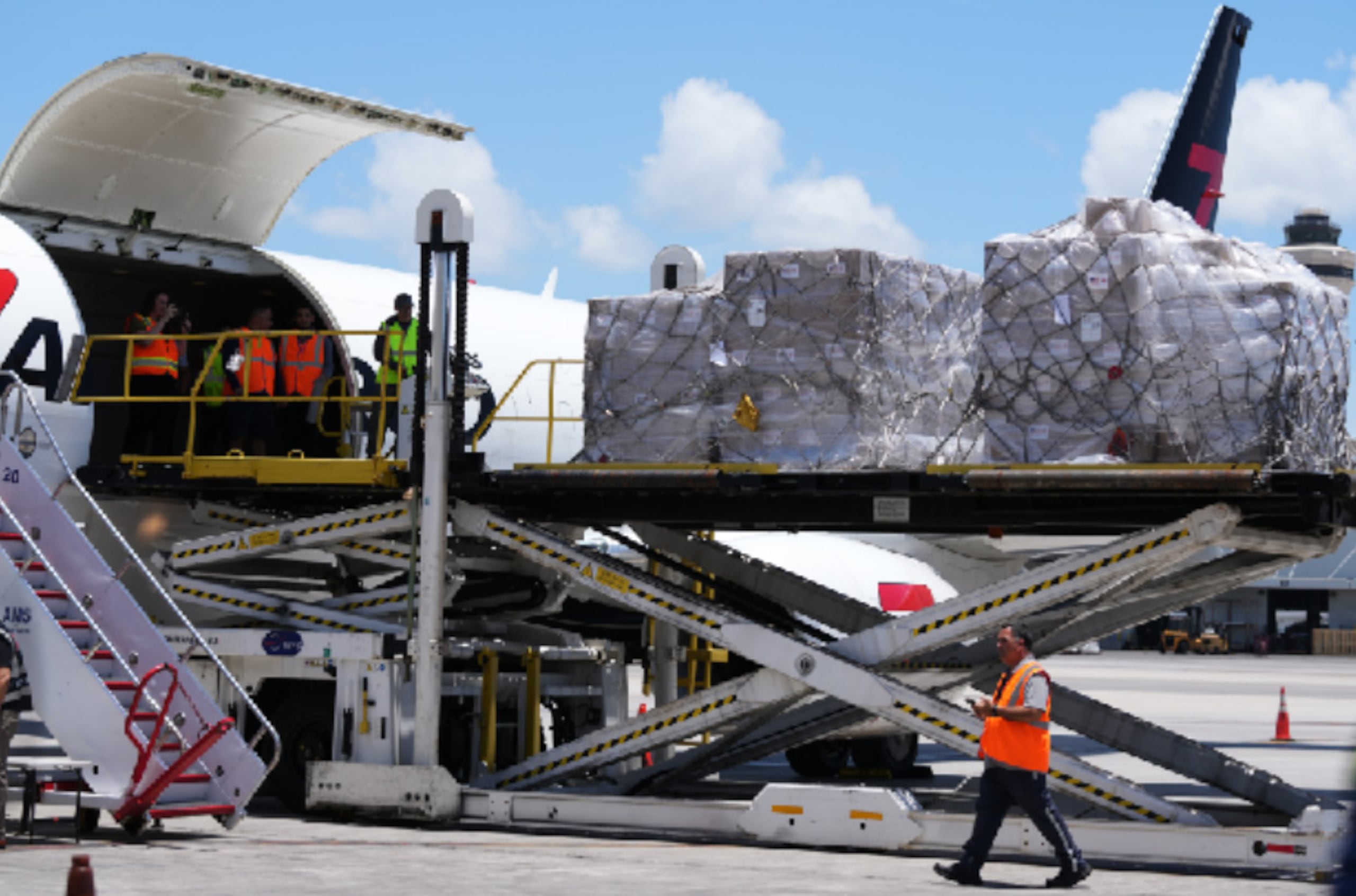 Personas cargan pales con alimentos y kits de higiene en un avión con destino a Cuba organizado por el gobierno de Estados Unidos. (AP Foto/Lynne Sladky)