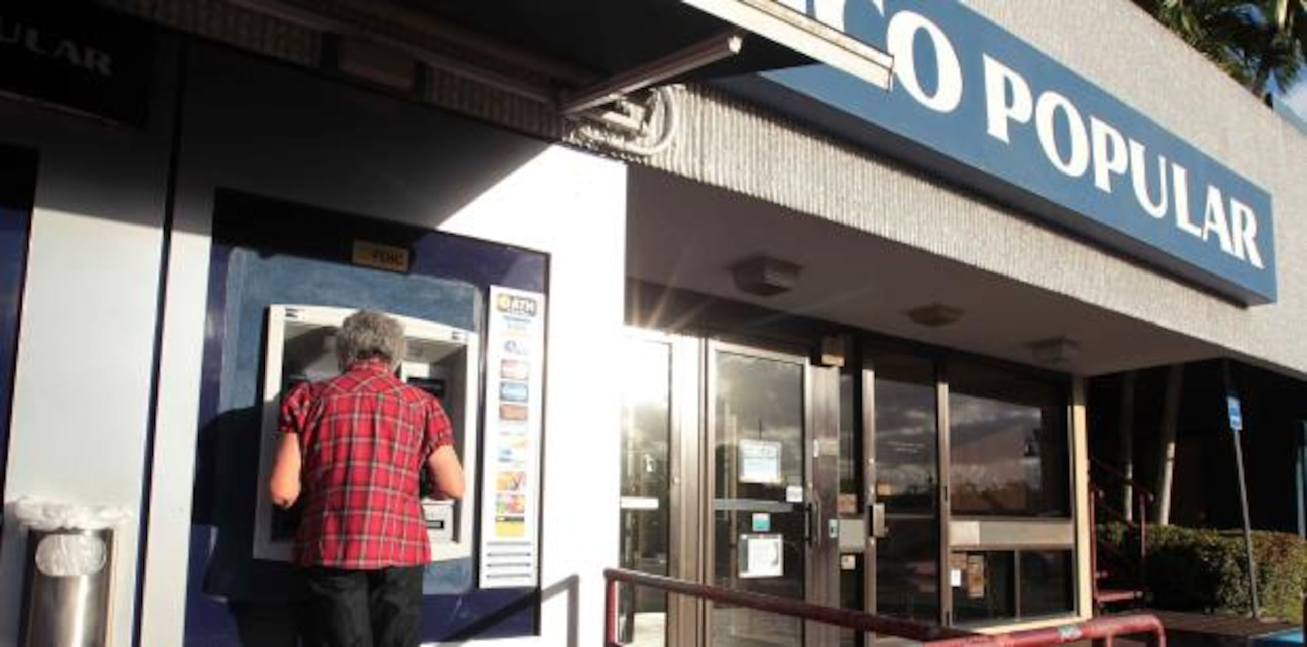 Una persona extrae dinero de una ATH del Banco Popular. (Archivo)