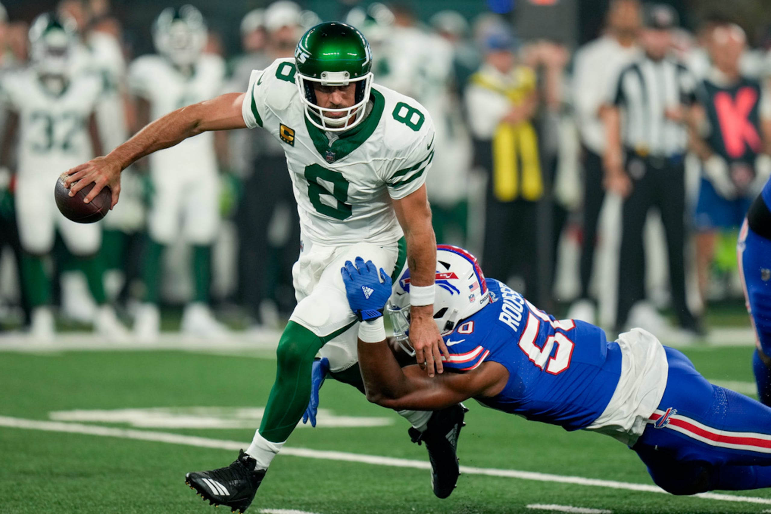 Aaron Rodgers, quarterback de los Jets de Nueva York, es derribado por Greg Rousseau, de los Bills de Buffalo.