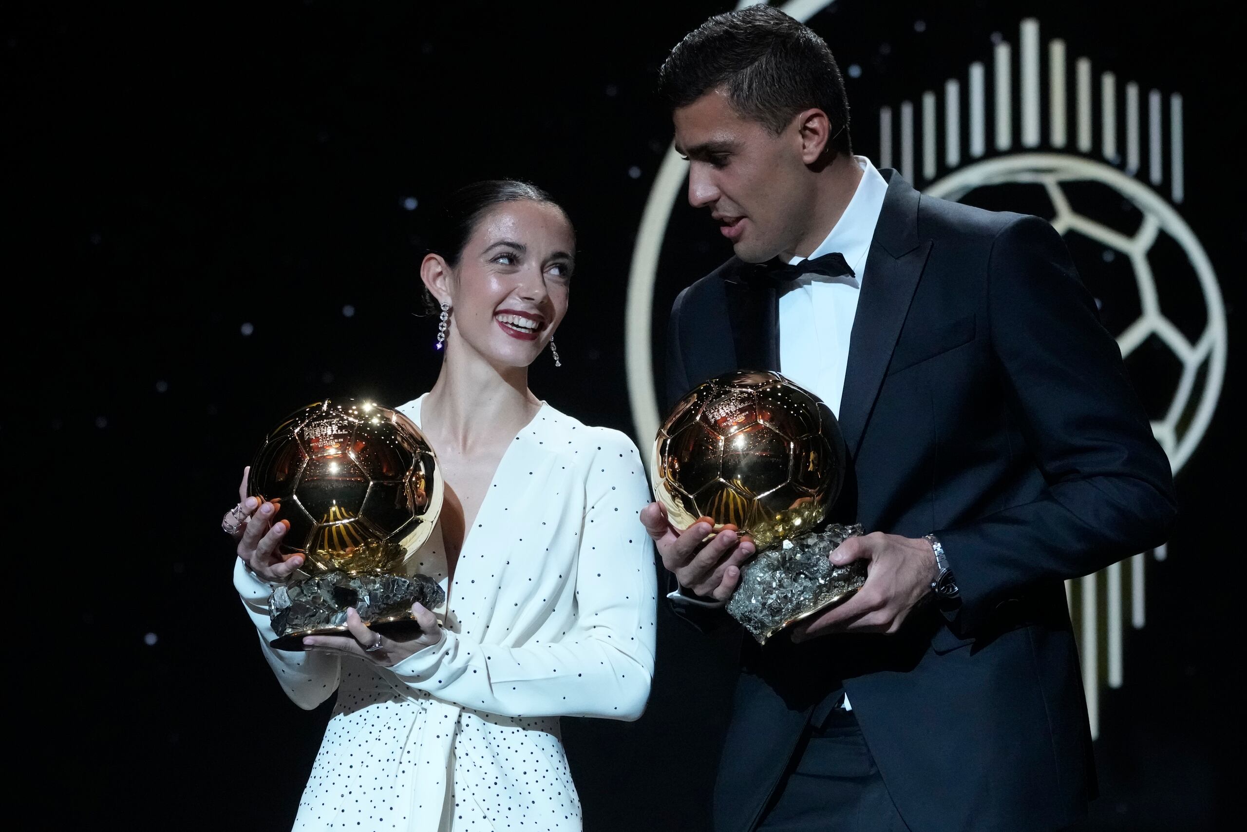 Los jugadores españoles Aitana Bonmatí (izquierda) y Rodri Hernández muestras sus trofeos al Balón de Oro, el lunes 28 de octubre de 2024, en París. (AP Foto/Michel Euler)