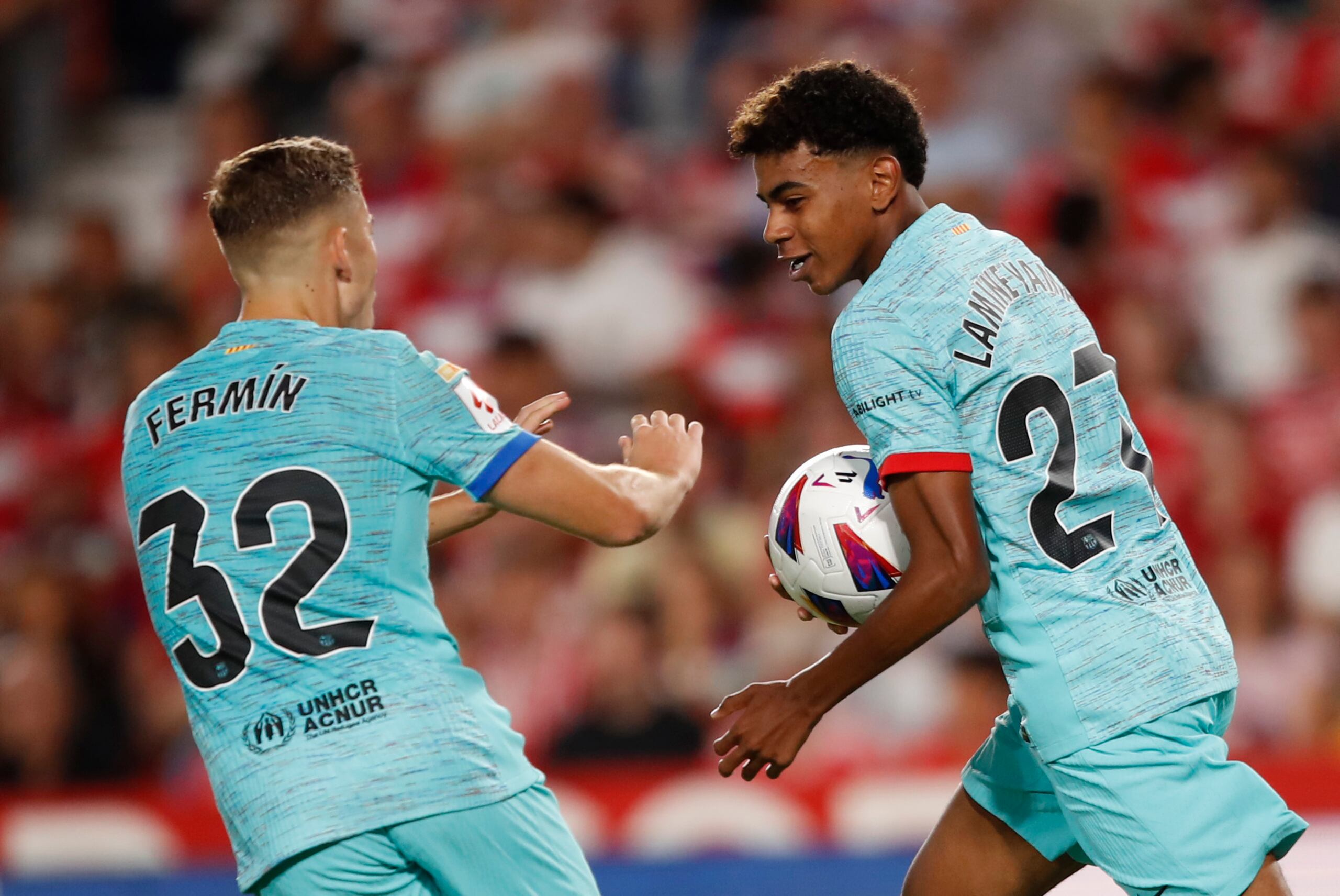 Lamine Yamal (derecha) celebra después de anotar el primer gol del Barcelona durante el partido de La Liga de España entre Granada y Barcelona en el estadio Los Carmanes, en Granada, España, el domingo 8 de octubre de 2023.  (AP Foto/Fermin Rodriguez)