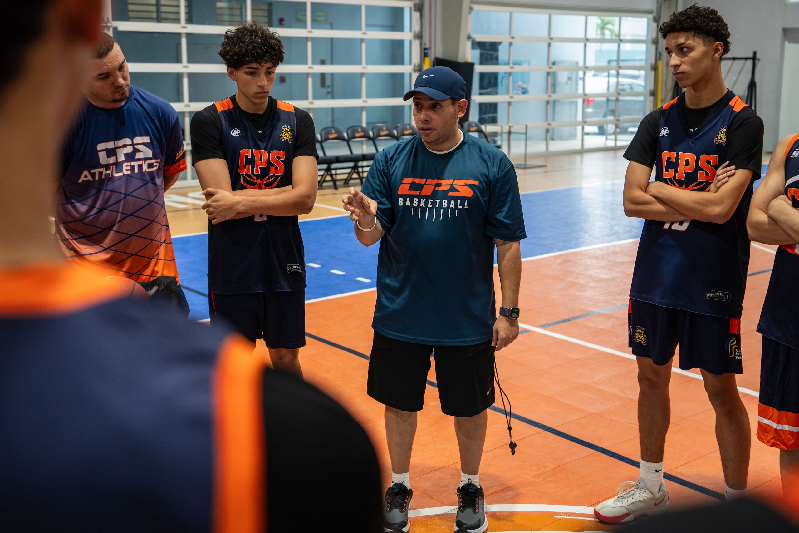 Leo Arill imparte instrucciones a los jugadores de Caguas Private School antes de una práctica.