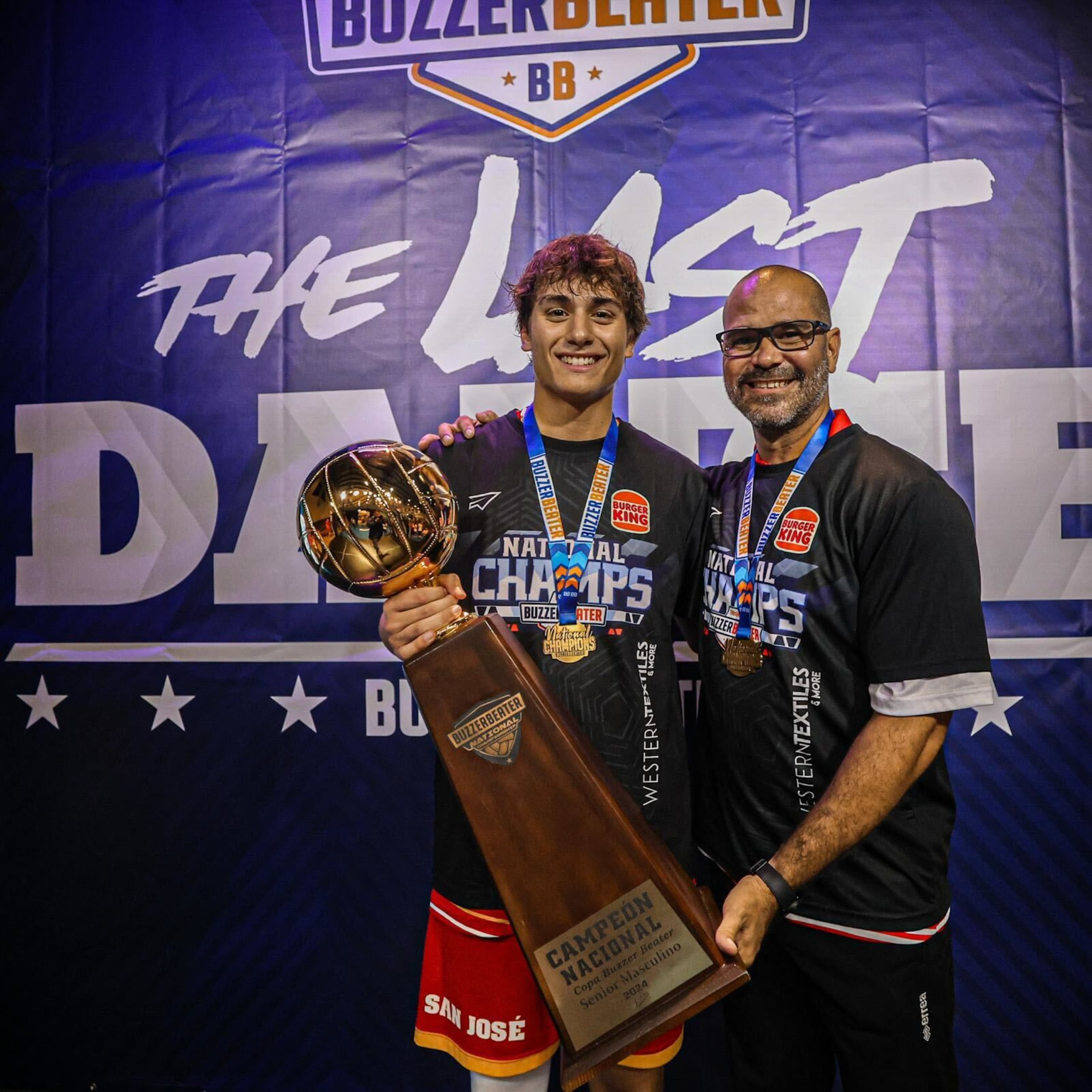 Jean Paul González, Jugador Más Valioso de la final de la Copa Buzzer Beater, sostiene el trofeo junto al dirigente Luis “Wicho” Aponte.