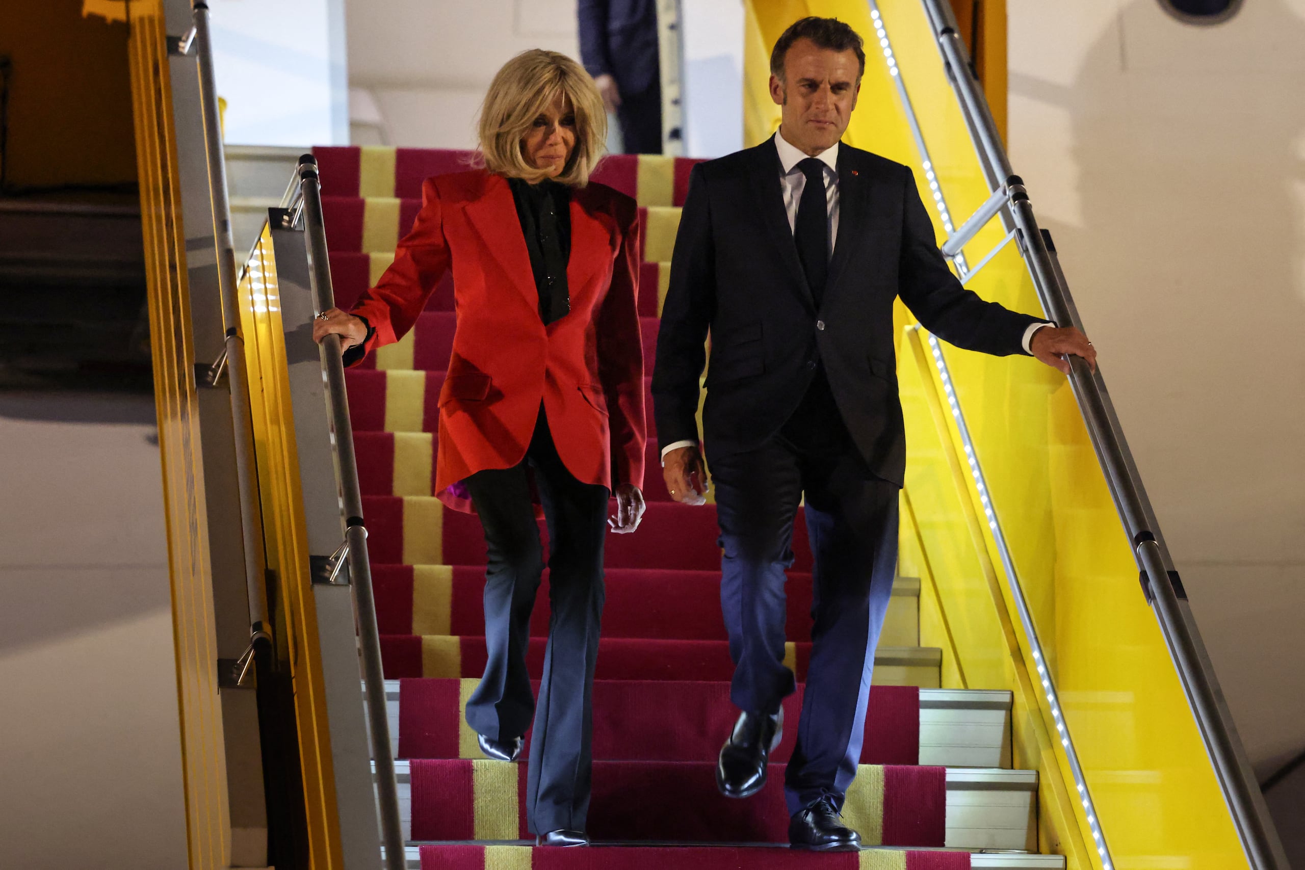 France's President Emmanuel Macron and his wife Brigitte Macron disembark from the plane upon their arrival at Noi Bai International Airport in Hanoi on May 25, 2025. French President Emmanuel Macron arrived in Hanoi on May 25, an AFP journalist saw, for the first leg of a Southeast Asia tour that will also see him travel to Indonesia and Singapore. (Photo by Ludovic MARIN / AFP)