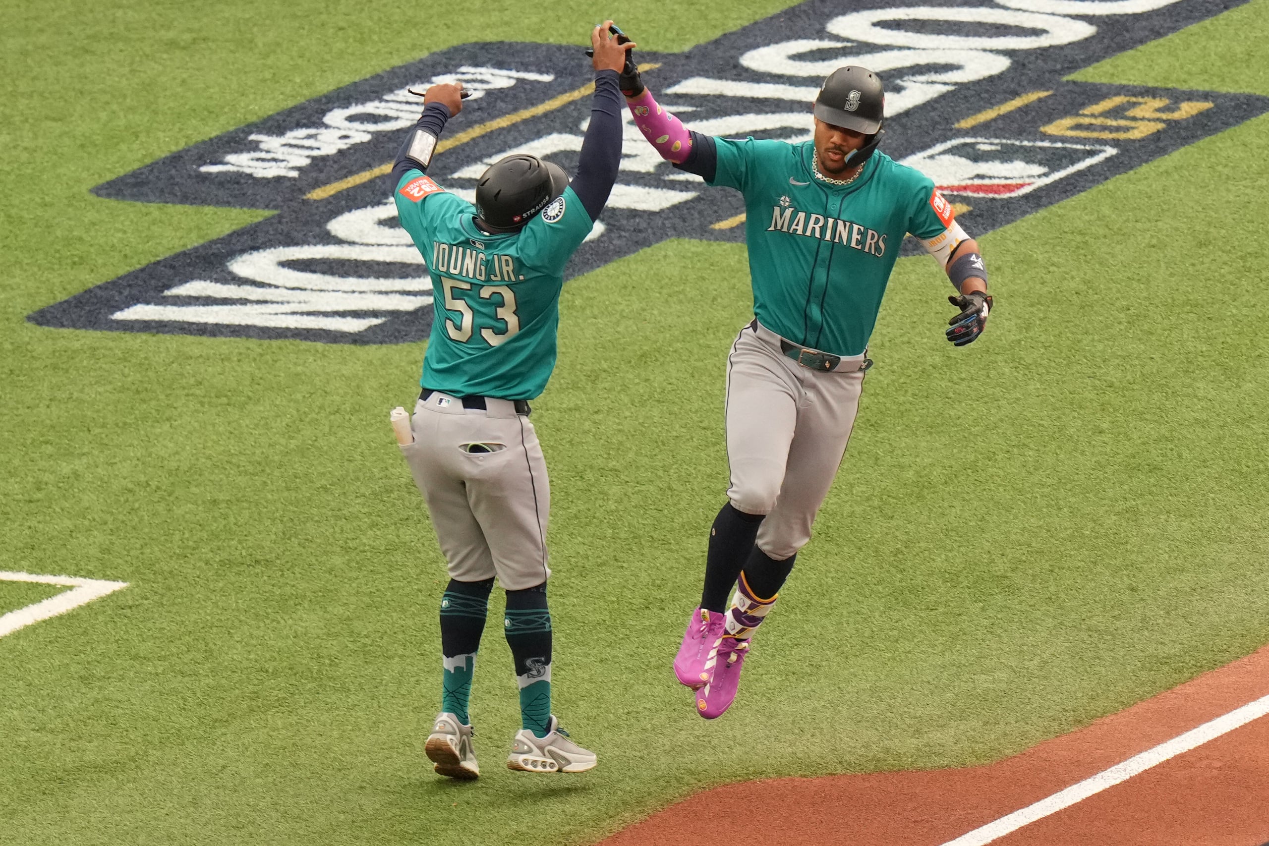 Julio Rodríguez, de los Marineros de Seattle (derecha), celebra con el entrenador de primera base Eric Young Jr. (53) mientras recorre las bases tras conectar un jonrón de tres carreras contra los Azulejos de Toronto durante la primera entrada del segundo juego de la Serie Divisional de la Liga Americana en Toronto.
