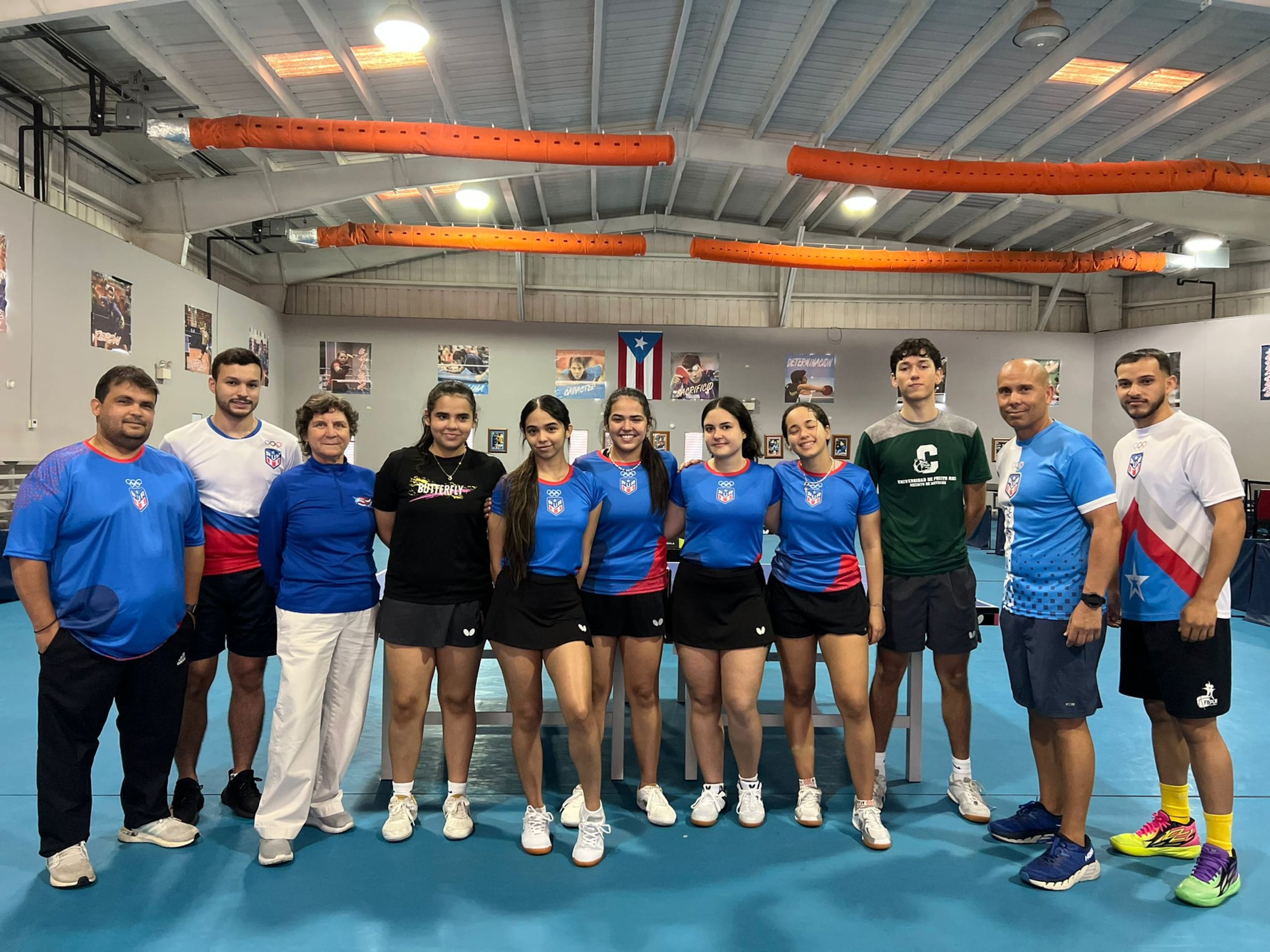 El equipo de tenis de mesa femenino junto al equipo de trabajo de profesionales durante el acuartelamiento en el club de Utuado.