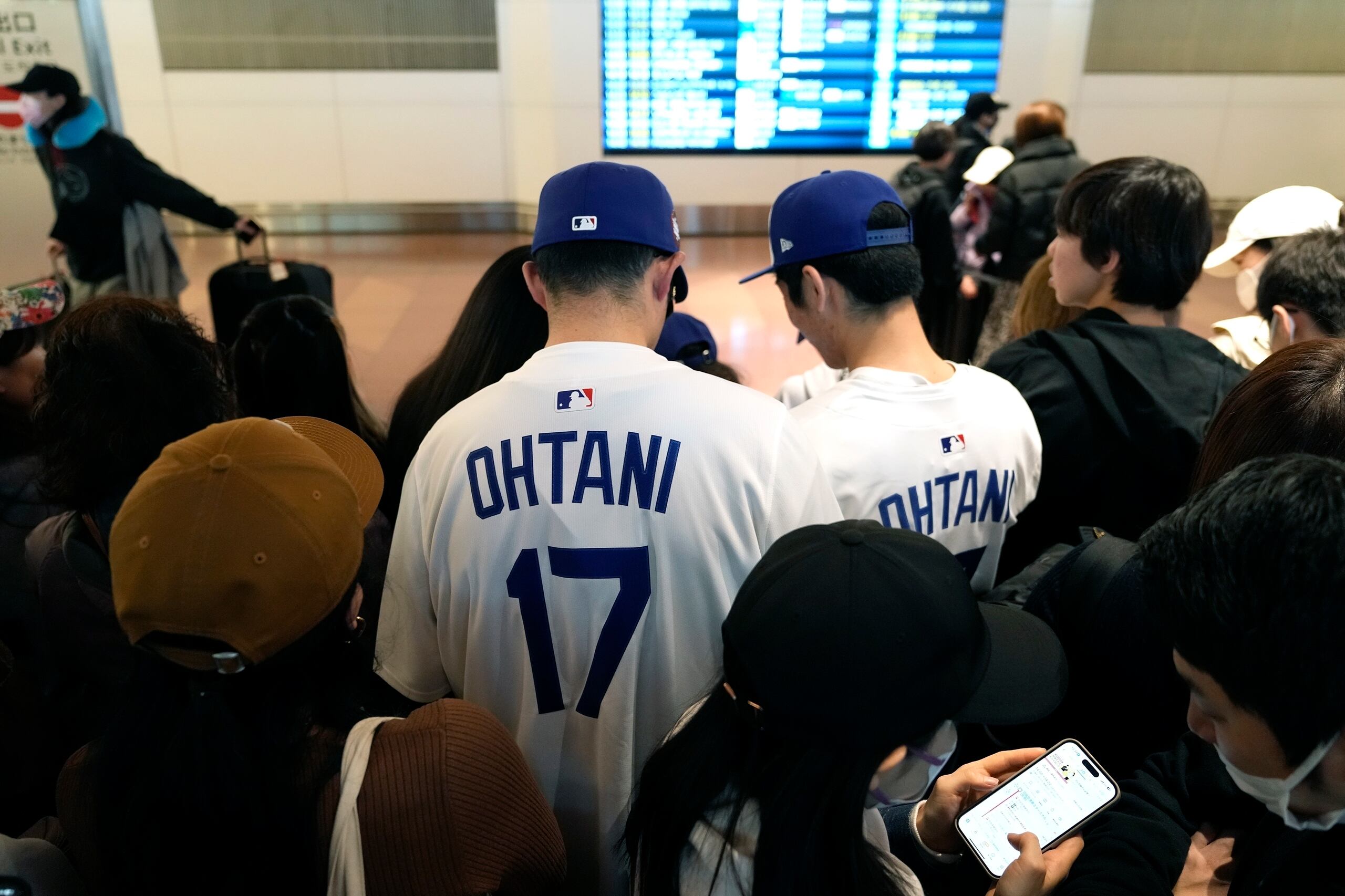 Fanáticos de Shohei Ohtani, astro de los Dodgers de Los Ángeles, aguardan el arribo del equipo en el aeropuerto internacional de Tokio, el jueves 13 de marzo de 2025. (AP Foto/Hiro Komae)
