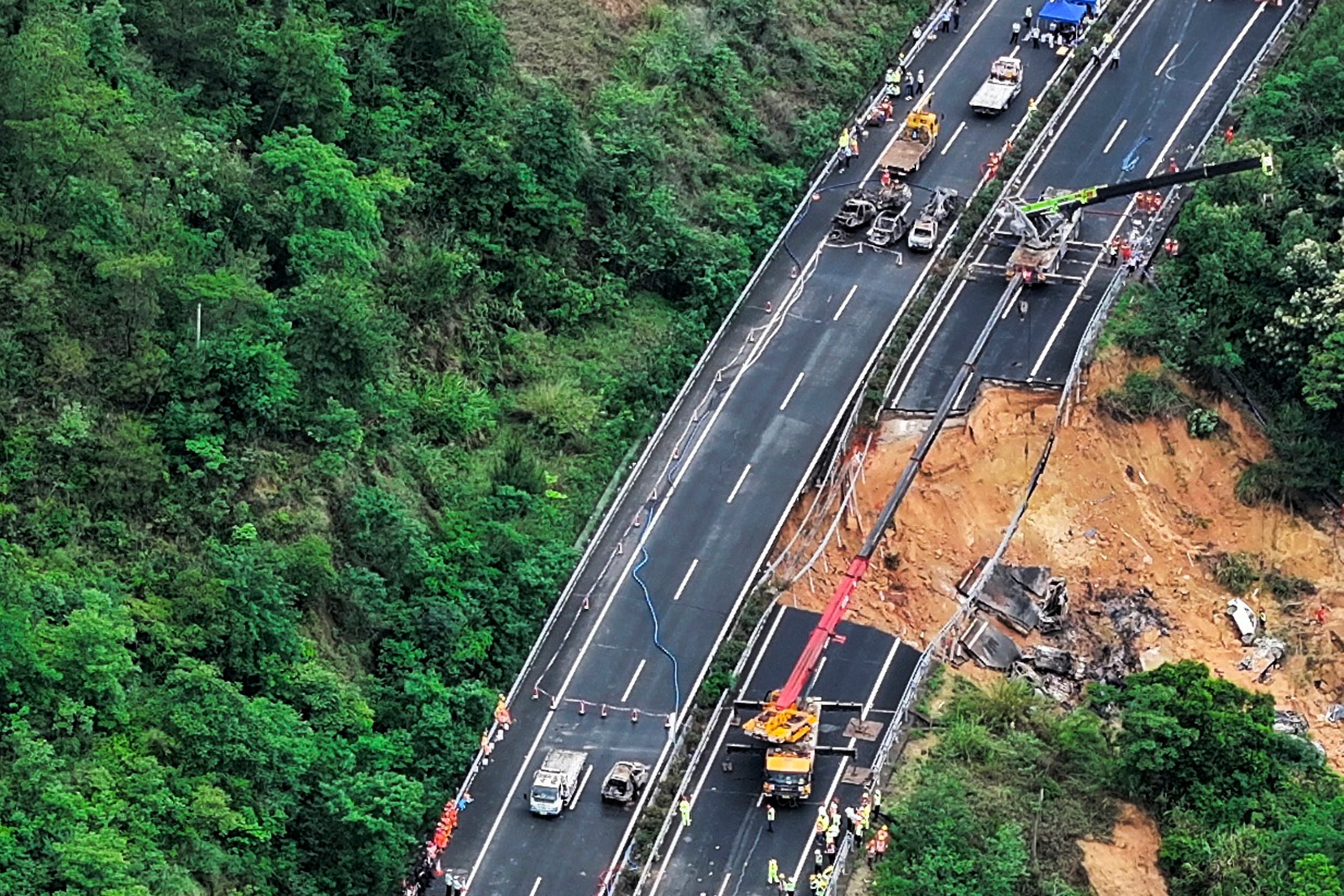 En esta imagen publicada por la agencia de noticias Xinhua, una imagen aérea muestra rescatistas trabajando en un tramo de carretera derrumbado en la autopista Meizhou-Dabu en Meizhou, en la provincia sureña de Guangdong, China (Agencia de noticias Xinhua via AP)