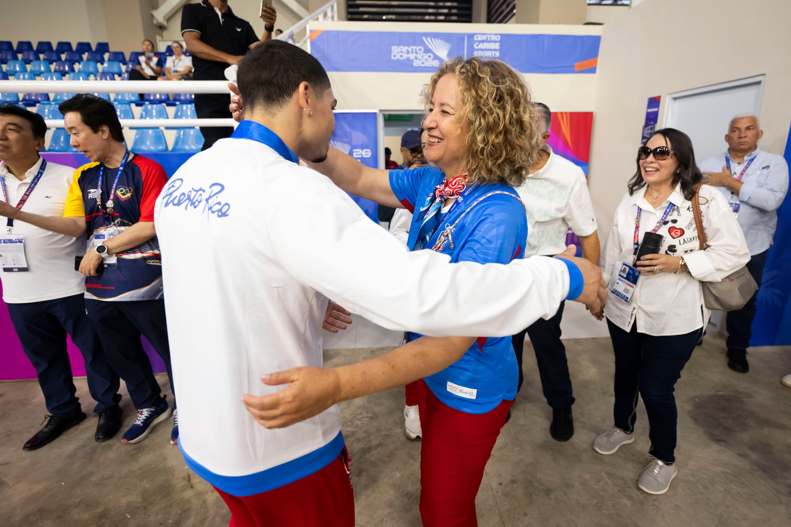 Sara Rosario, aquí abrazando al medallista de teakwondo Adrián Benítez, está súper contenta por la actuación de Puerto Rico en Santo Domingo 2026 al momento.