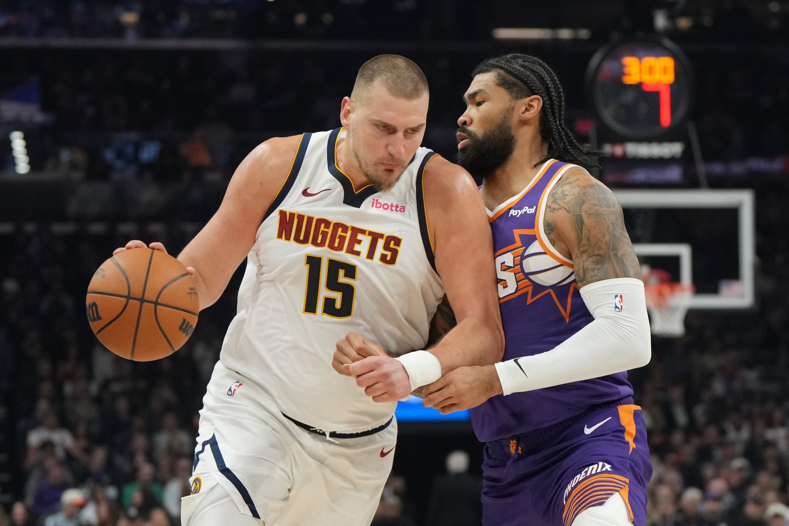 El serbio Nikola Jokic, de los Nuggets de Denver, avanza frente a Nick Richards, de los Suns de Phoenix, el sábado 29 de noviembre de 2025 (AP Foto/Rick Scuteri)