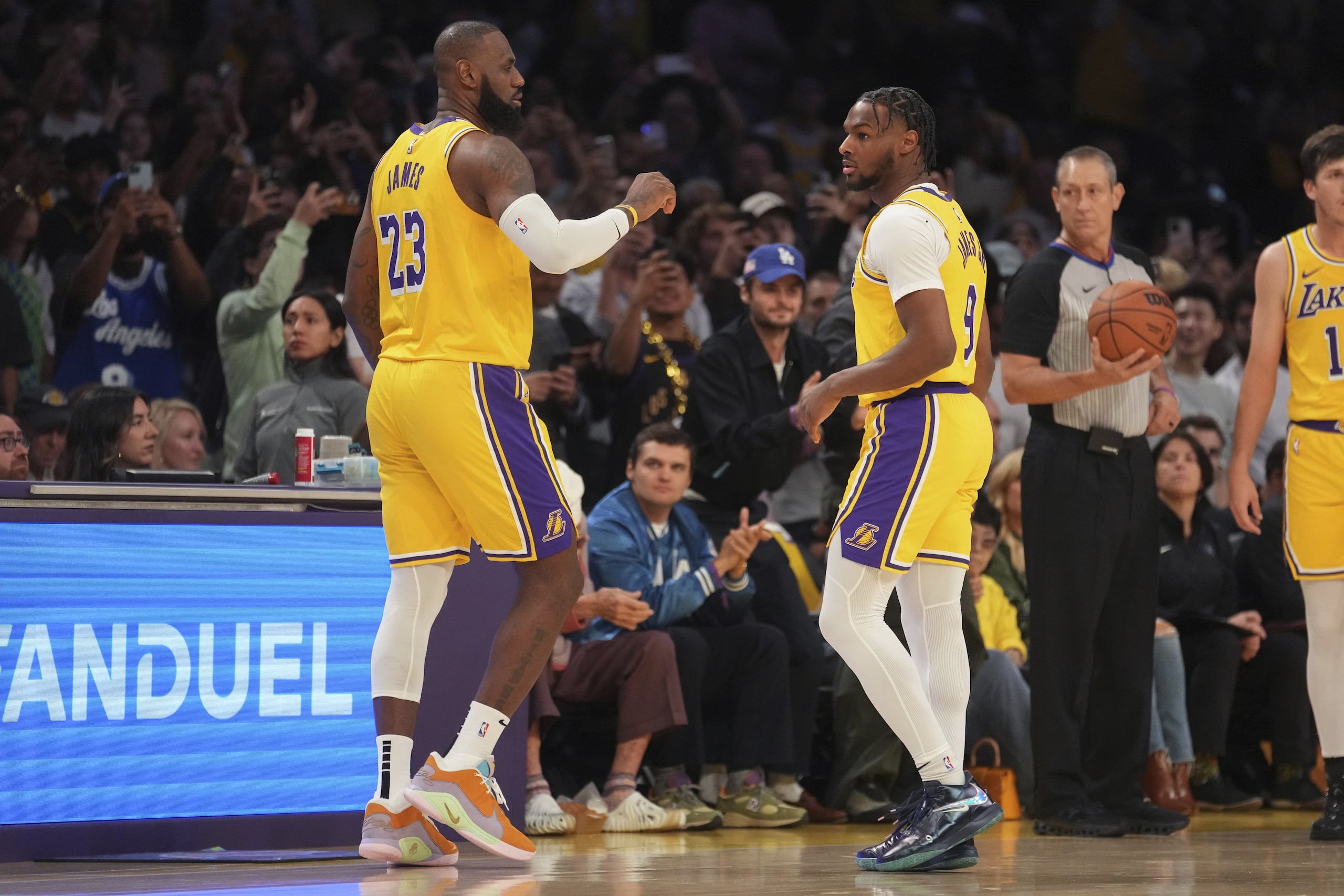LeBron James y su hijo mayor Bronny James juntos en la cancha durante el partido de NBA entre los Lakers y los Timberwolves.