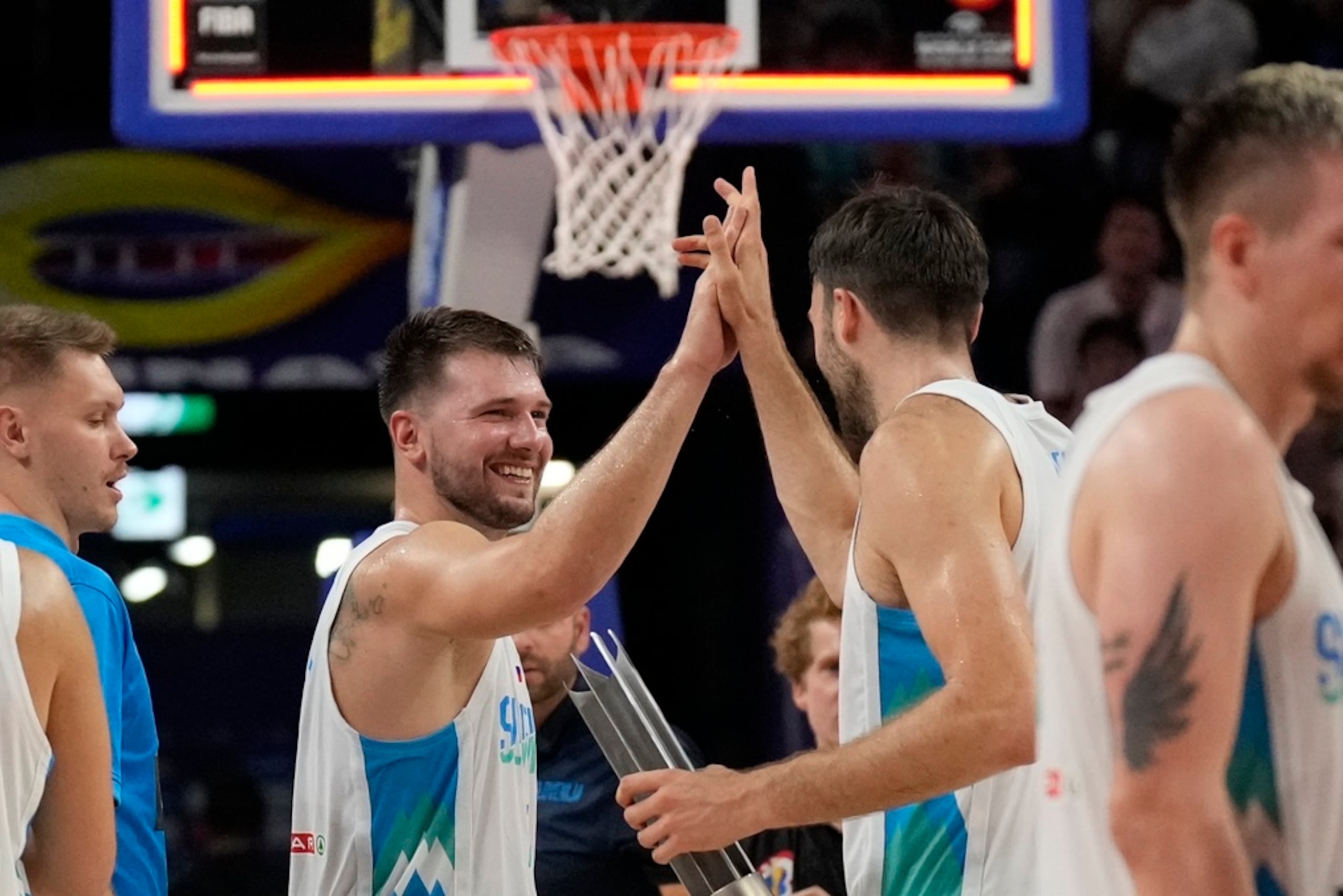 Luka Doncic celebra con su compañero Mike Tobey al vencer a Australia en la segunda ronda de la Copa Mundial.