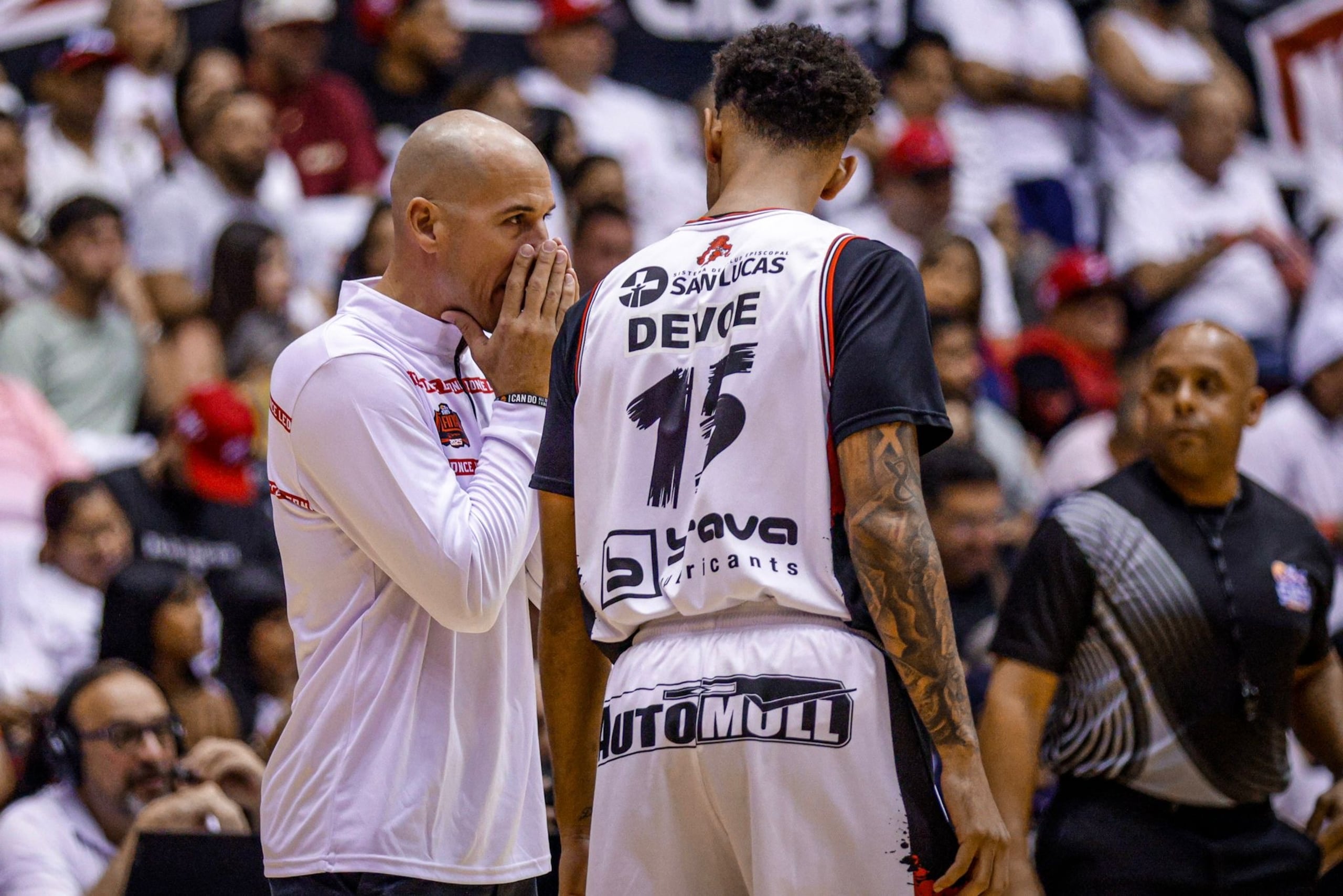 El dirigente Carlos Rivera le imparte instrucciones al refuerzo Michael Devoe en el cuarto juego de la final del BSN.