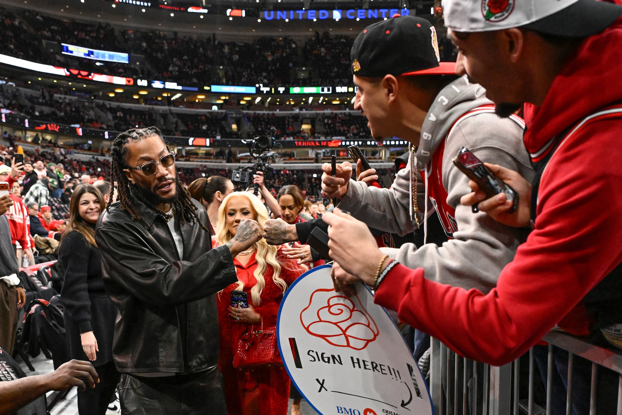 Derrick Rose saluda a fanáticos previo al partido de los Bulls de Chicago, noche que su camiseta fue retirada.