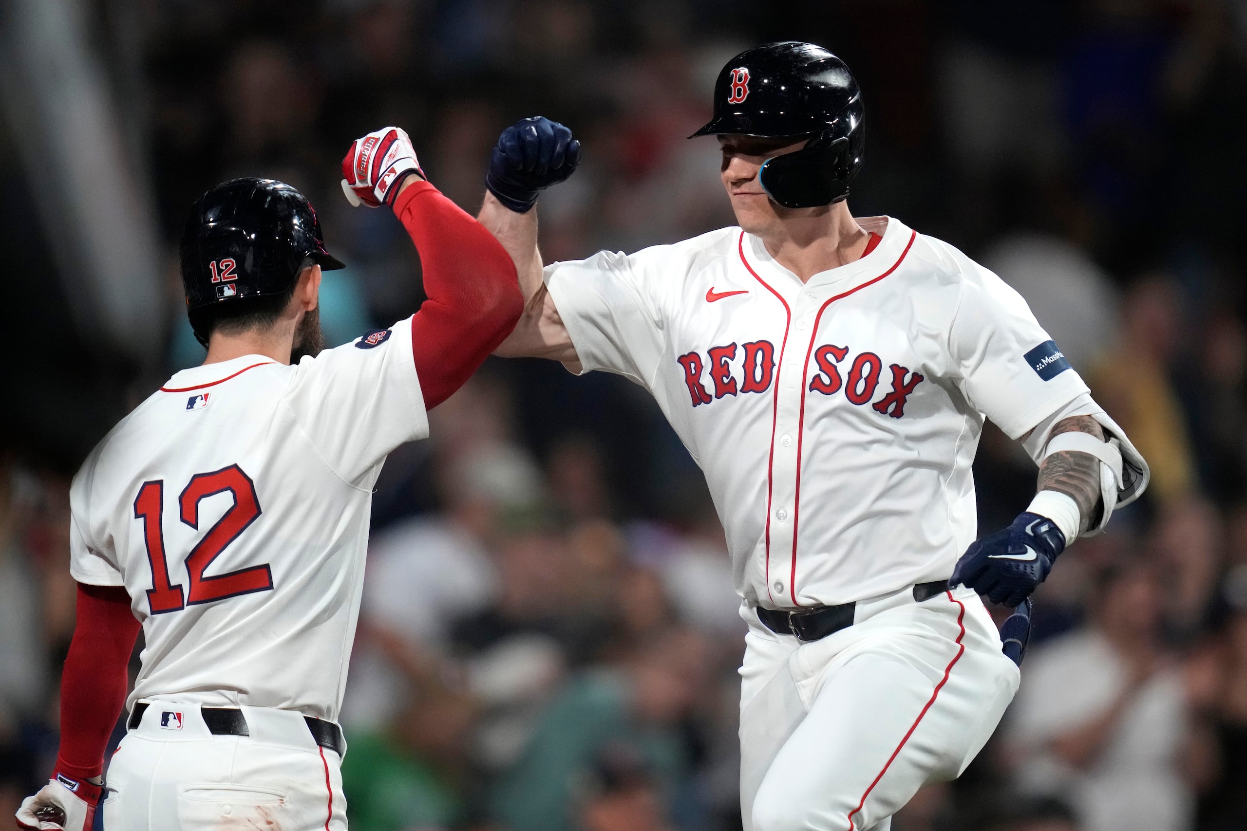 Tyler O'Neill (derecha), de los Red Sox, es felicitado por Connor Wong (12) tras su jonrón solitario ante el lanzador de los Orioles de Baltimore, Cade Povich durante el tercer episodio del juego de béisbol en el Fenway Park, el lunes 9 de septiembre de 2024, en Boston.