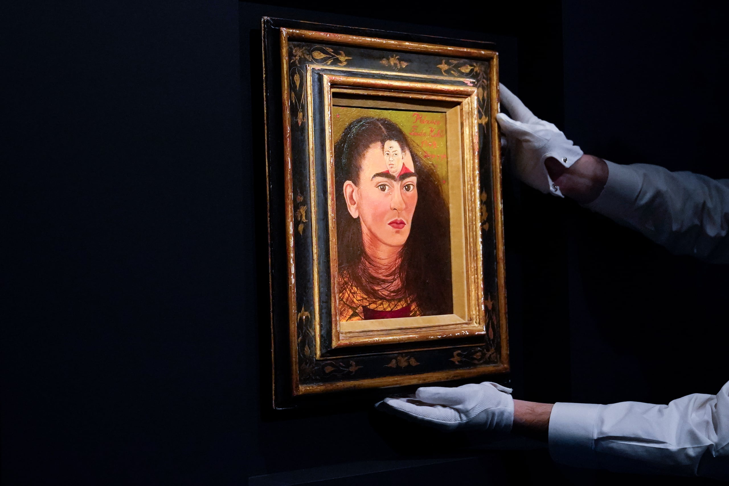 Una persona ajusta "Diego y yo" de Frida Kahlo en una exhibición en la casa de subastas Sotheby's durante una vista previa para la prensa de la subasta Modern Evening, el 5 de noviembre de 2021, en Nueva York. El 70 aniversario de la muerte de Kahlo es el 13 de julio de 2024. (AP Foto/Mary Altaffer, Archivo)