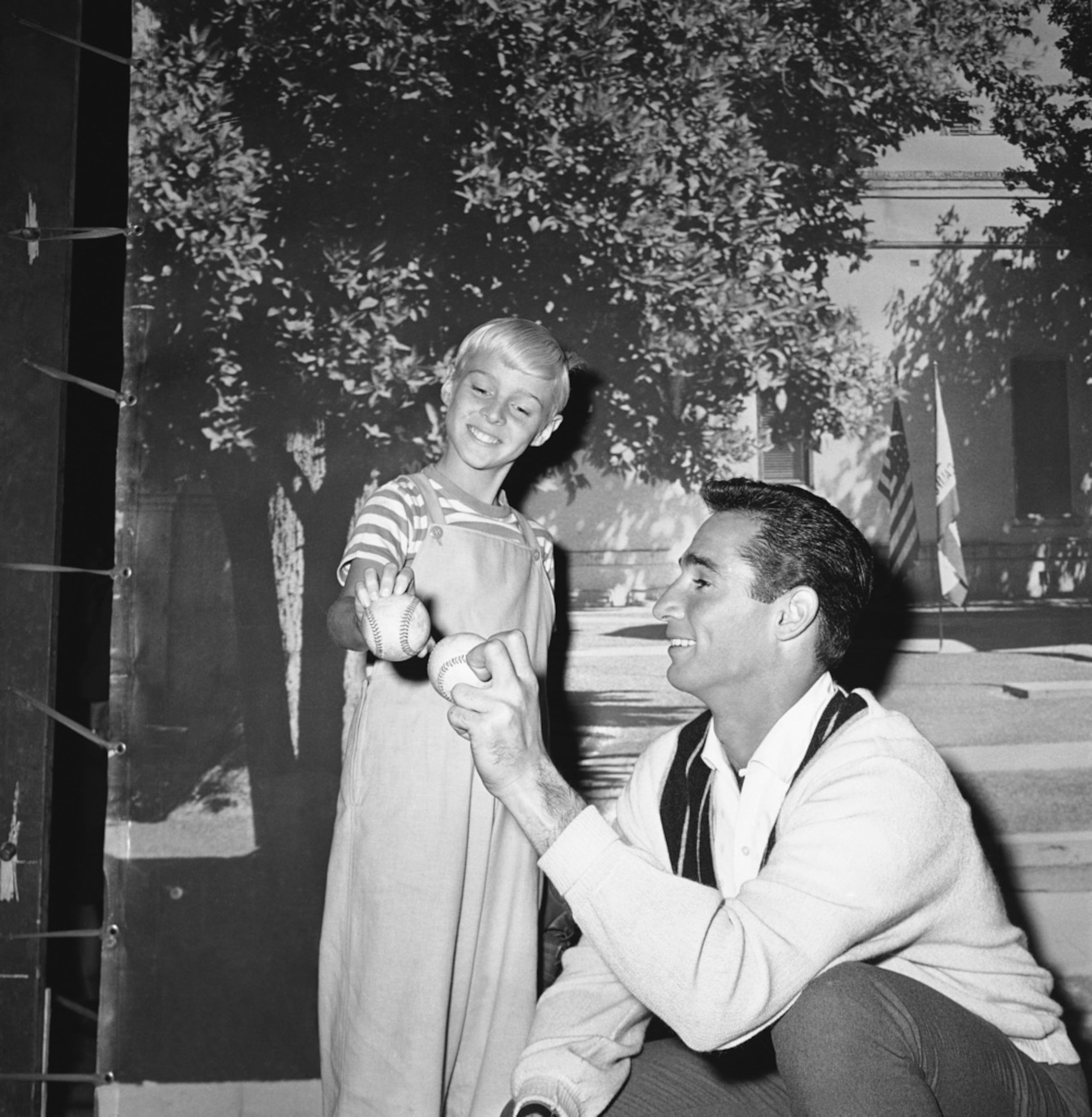 El lanzador de los Los Angeles Dodgers, Sandy Koufax, a la derecha, le da algunos consejos al actor de televisión Jay North sobre cómo lanzar, el 22 de febrero de 1962, en Los Ángeles.