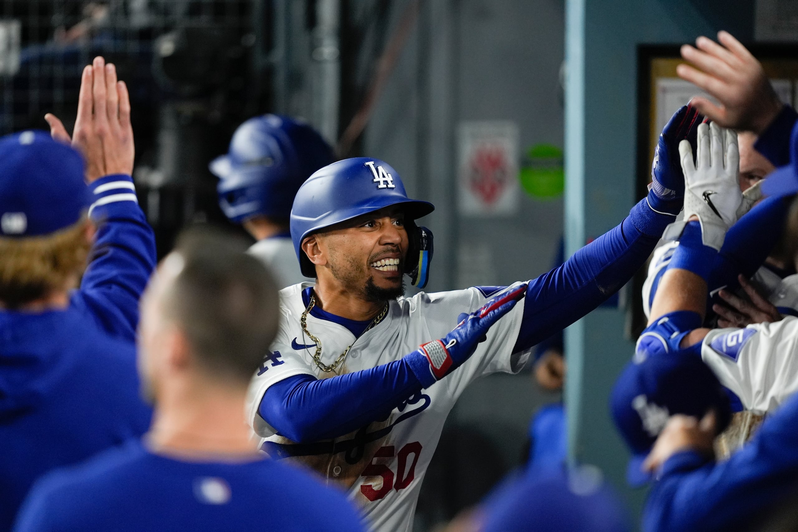 Mookie Betts, de los Dodgers de Los Ángeles, recibe la felicitación de sus compañeros tras un jonrón ante los Giants de San Francisco.