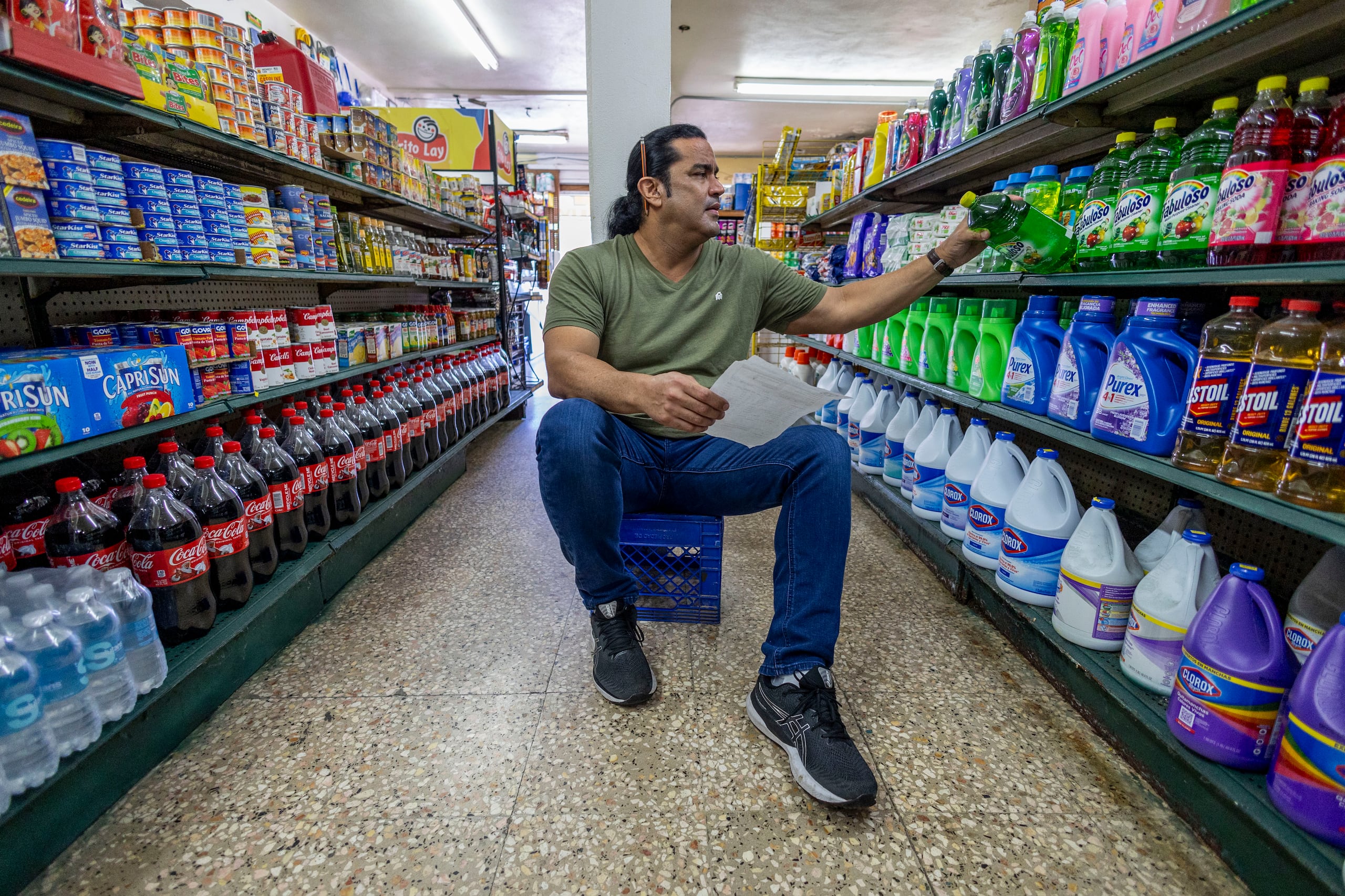 Ray González hace de todo en el colmado, desde atender clientes hasta abastecer las góndolas. Y además aún se mantiene activo en la lucha libre.