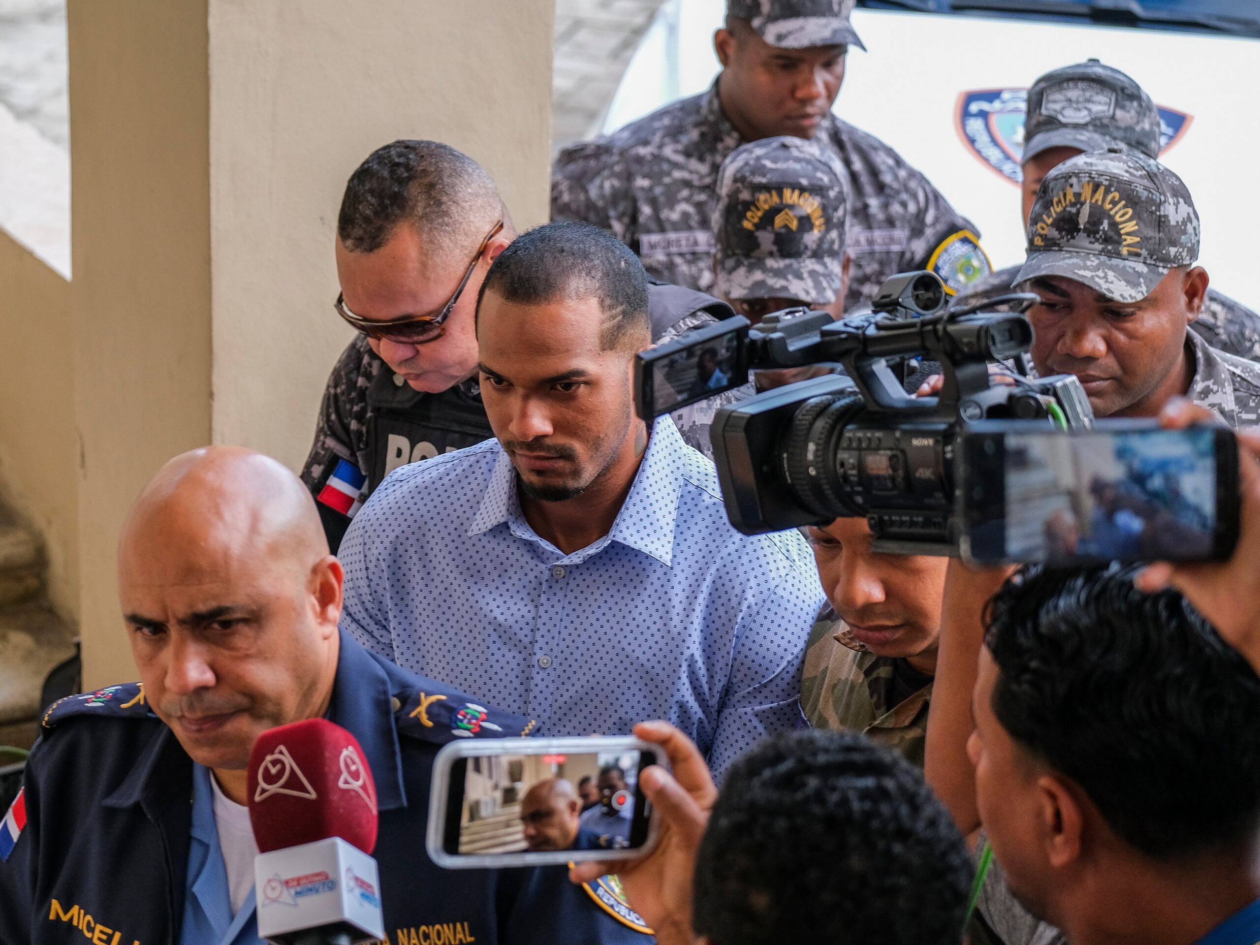 Wander Franco, centro, campocorto de los Rays de Tampa Bay, es escoltado por oficiales de policía a su llegada al tribunal en Puerto Plata.