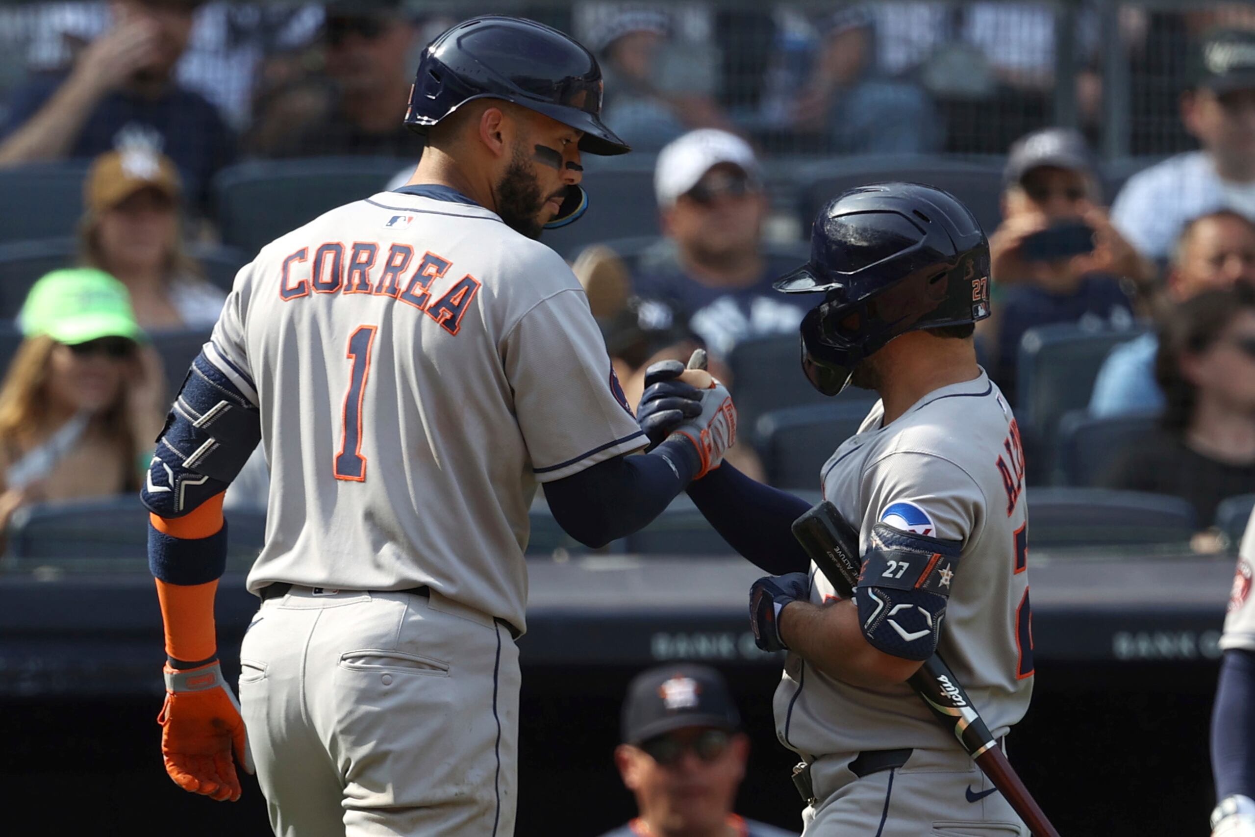 Carlos Correa, izquierda, de los Astros de Houston y José Altuve, derecha, reaccionan después de que Correa pegara un cuadrangular durante la novena entrada del juego de béisbol en contra de los Yankees de Nueva York.