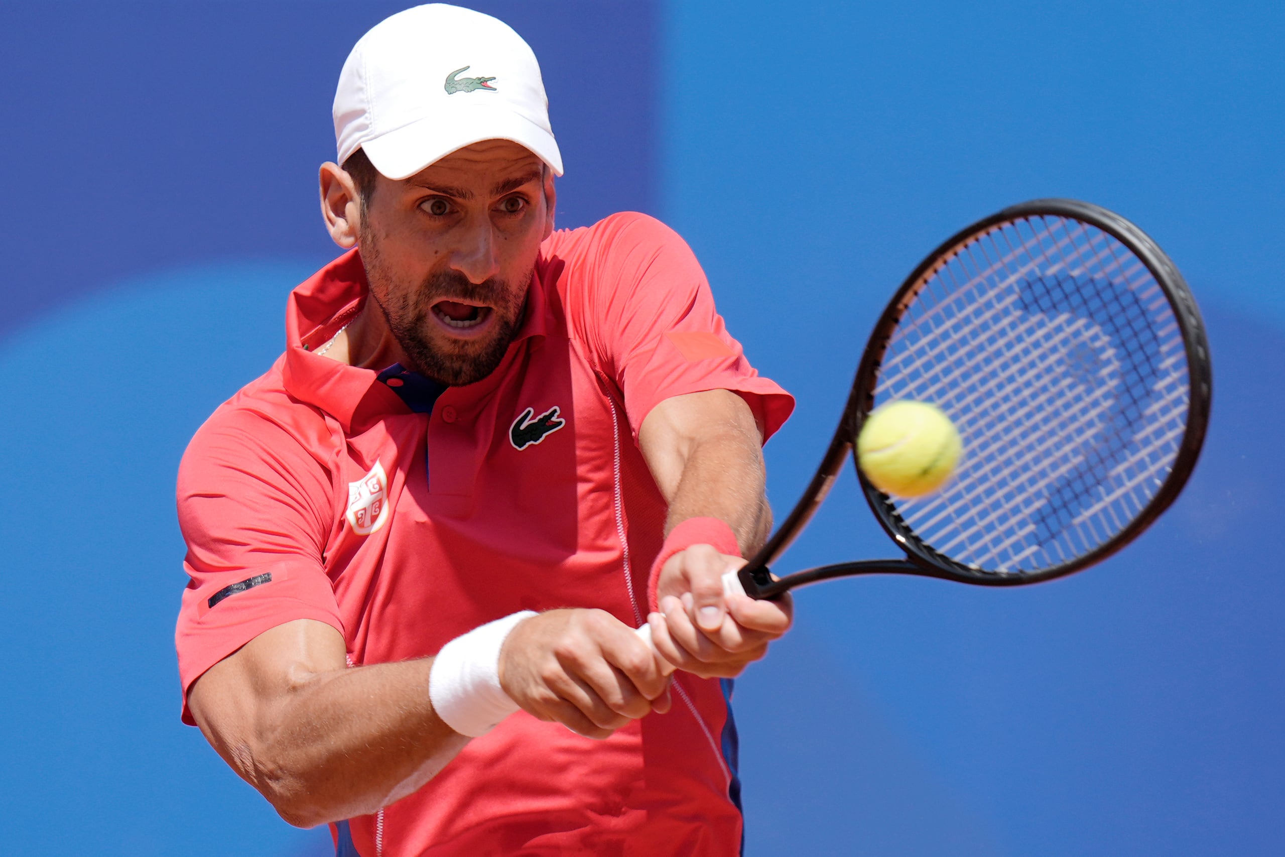 El serbio Novak Djokovic le pega con las dos manos a la pelota ante el español Rafael Nadal durante el partido de la segunda ronda del tenis de los Juegos Olímpicos en el estadio Roland Garros, el lunes 29 de julio de 2024, París, Francia. (AP Foto/Andy Wong)