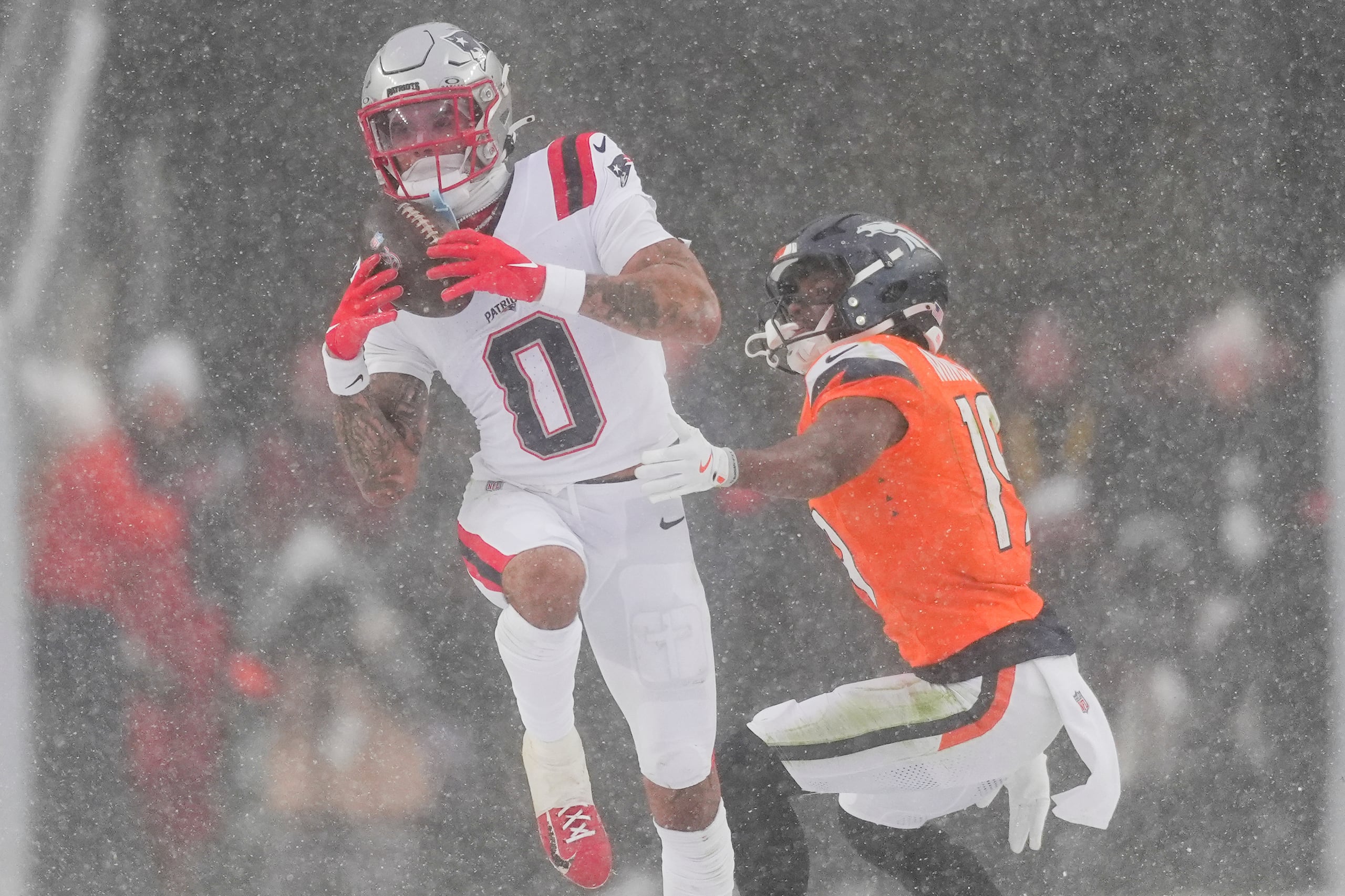 Christian Gonzalez (0), cornerback de los Patriots de Nueva Inglaterra, intercepta un pase que buscaba las manos de Marvin Mims Jr. (19), de los Broncos de Denver, durante la segunda mitad del Juego de Campeonato de la AFC de la NFL, el domingo 25 de enero de 2026, en Denver. (AP Foto/David Zalubowski)
