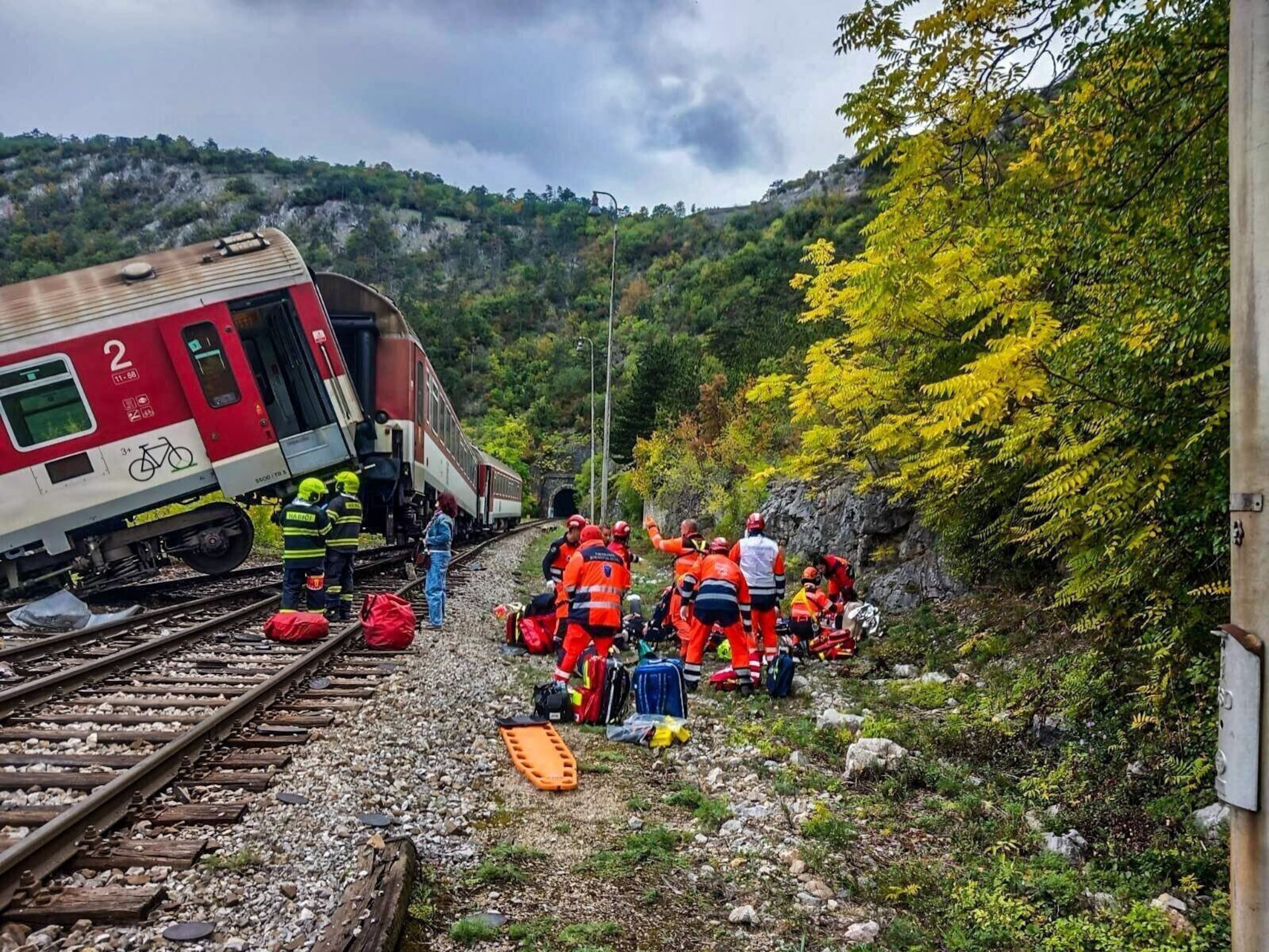 En esta imagen publicada por la policía eslovaca, rescatistas atienden a pasajeros heridos tras un choque de trenes cerca de Roznava, Eslovaquia, el lunes 13 de octubre de 2025. (Slovak Police via AP)