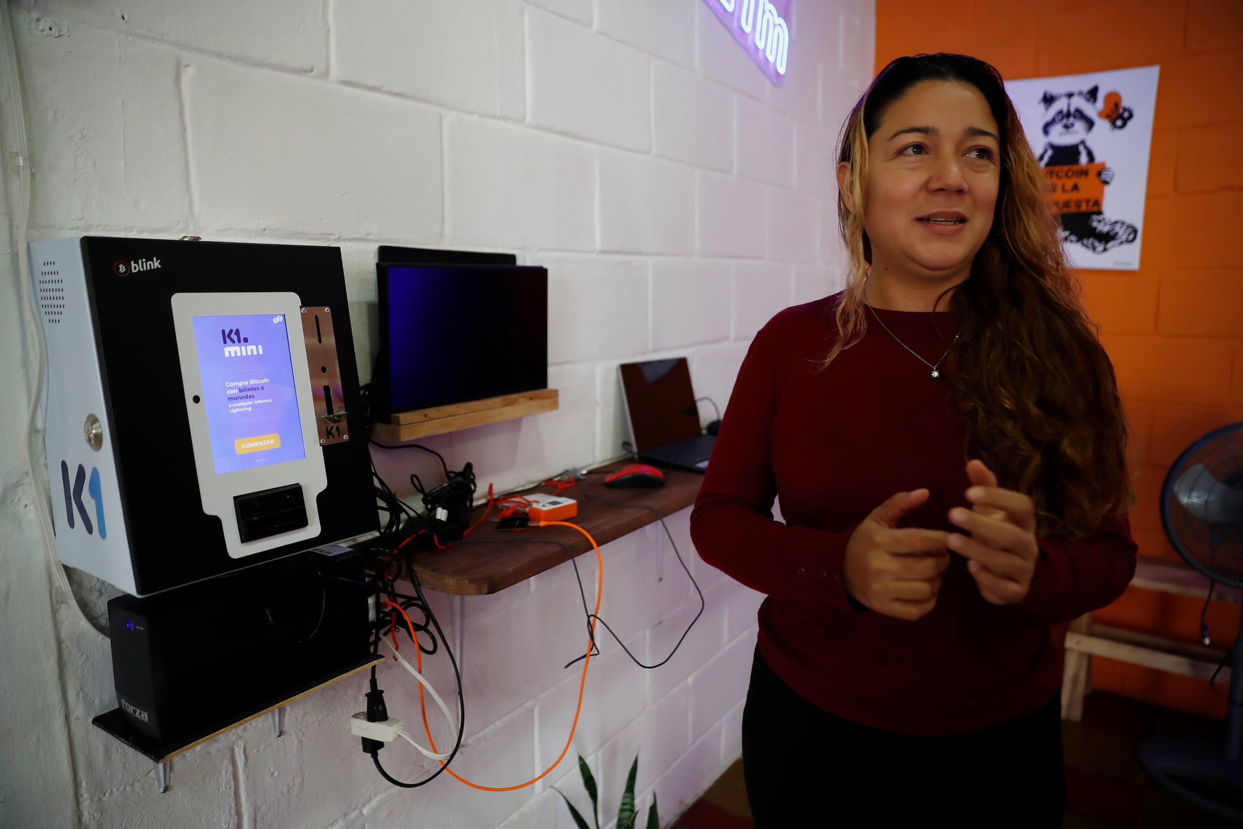 Patricia, facilitadora en el Centro Comunitario Botcóin, explicando el uso de algunas equipos tecnológicos realcionados a la compra de criptomoneda, el 4 de septiembre en Berlín, en El Salvador. (EFE/Rodrigo Sura)