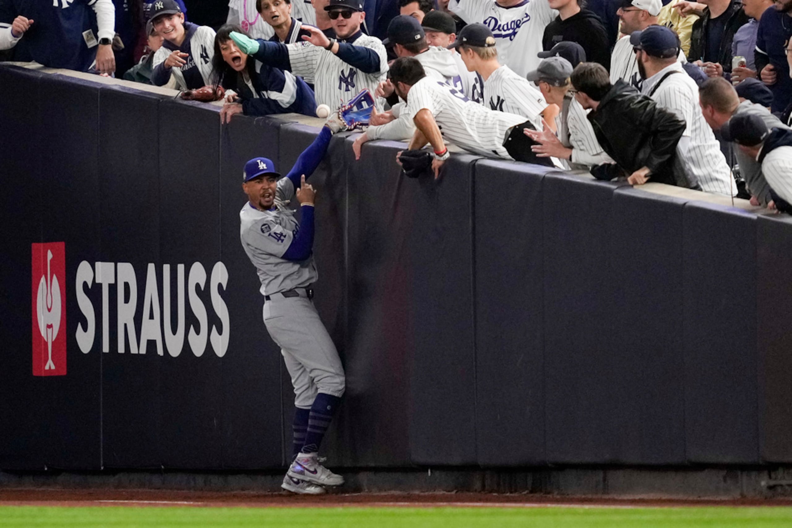 Dos fans que arrancaron la bola del guante del jardinero de los Dodgers Mookie Betts (AP Photo/Ashley Landis)