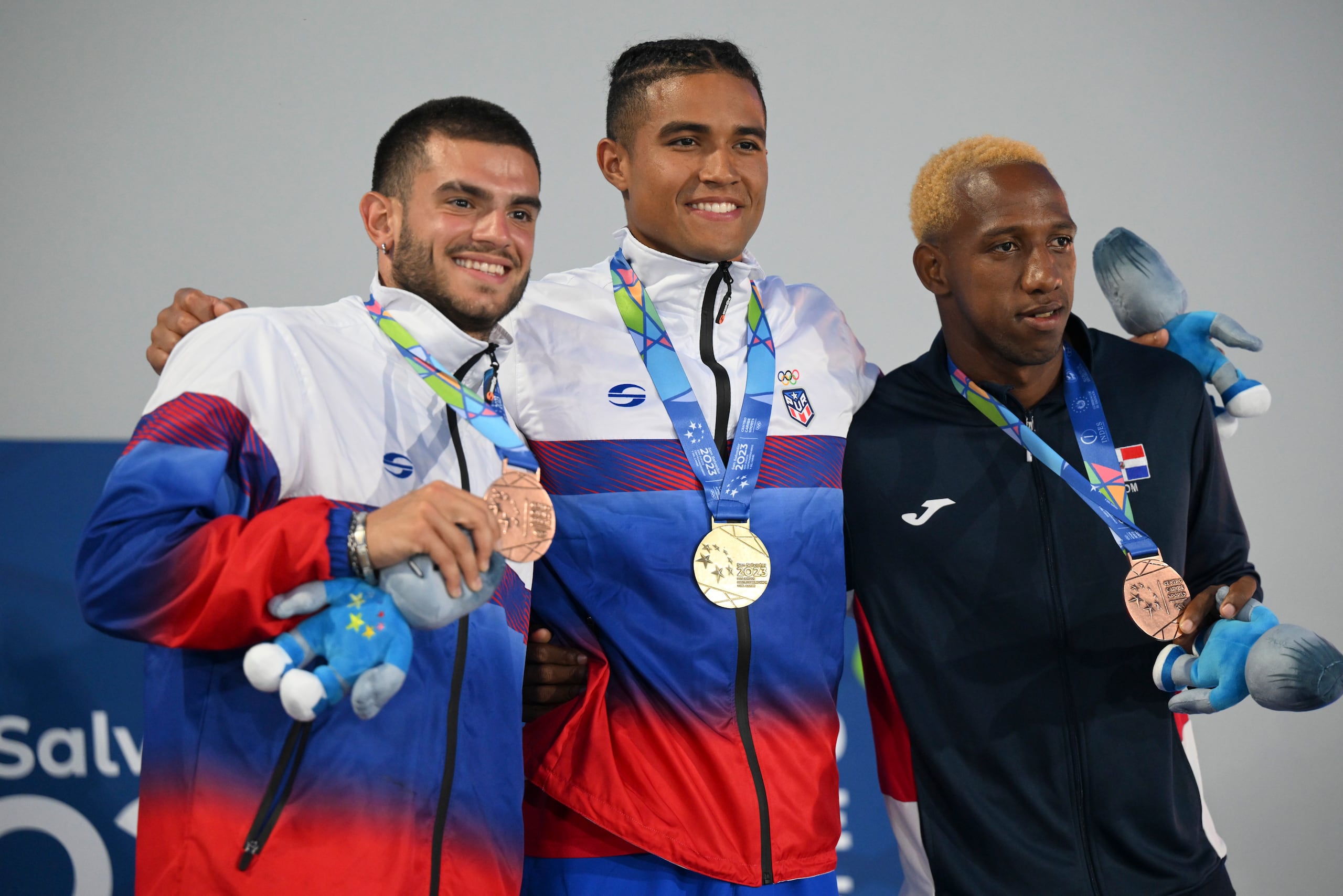 Ayden Owens, al centro y junto al también decaista boricua Yariel Soto (izquierda), en el podio de los JCC San Salvador 2023.