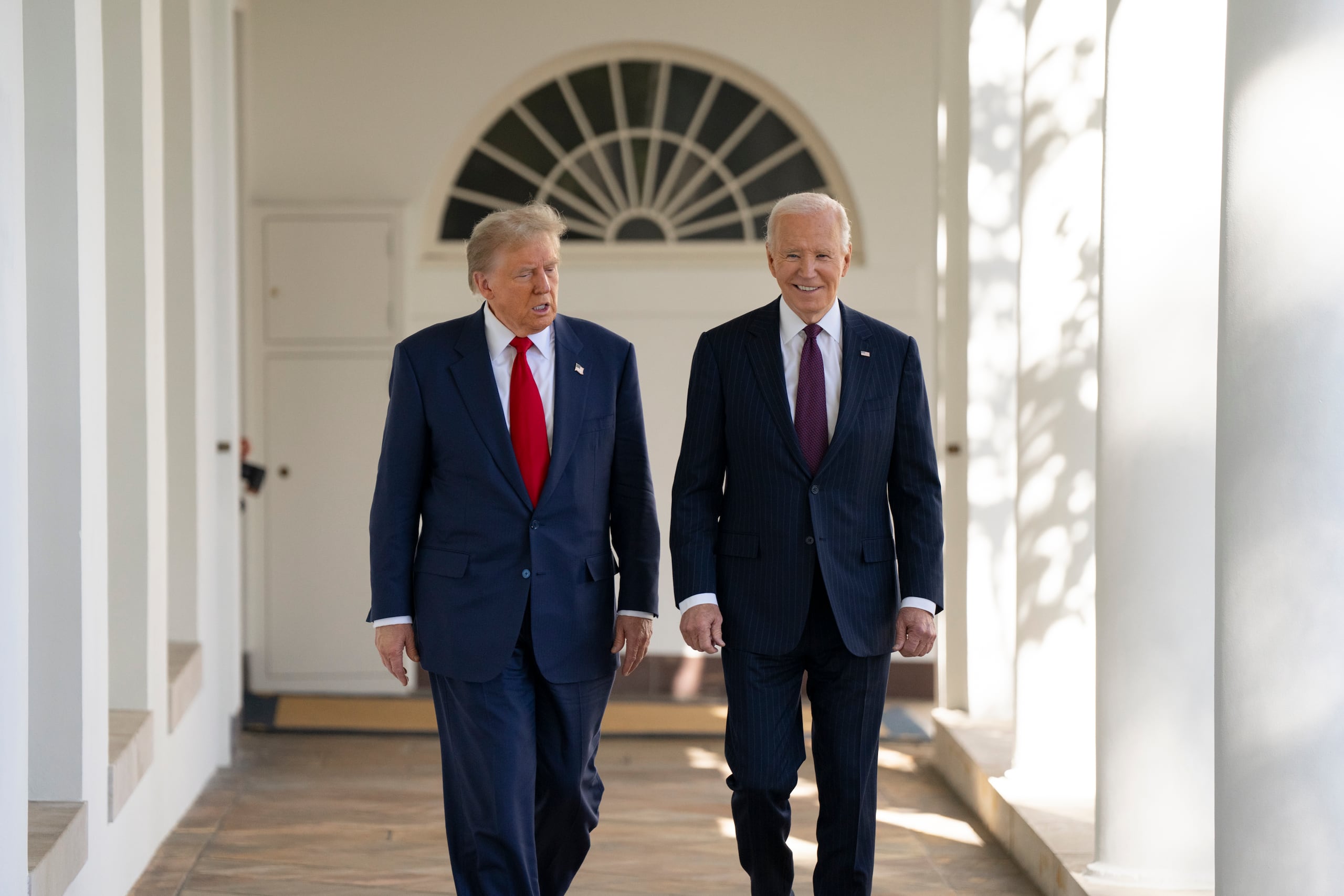 Donald Trump camina junto a Joe Biden.