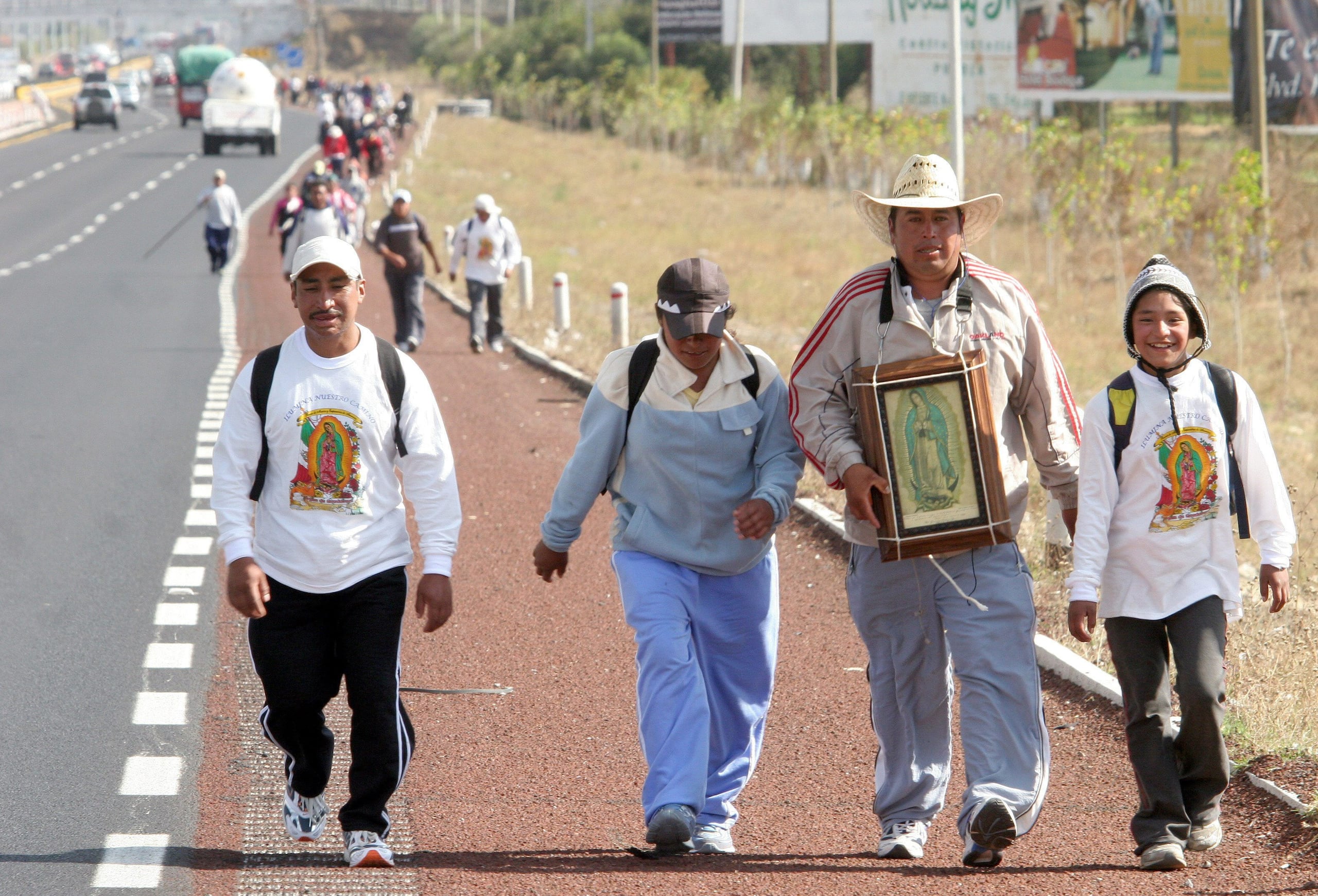 Peregrinos caminan por una autopista previo a los festejos de la Virgen de Guadalupe.