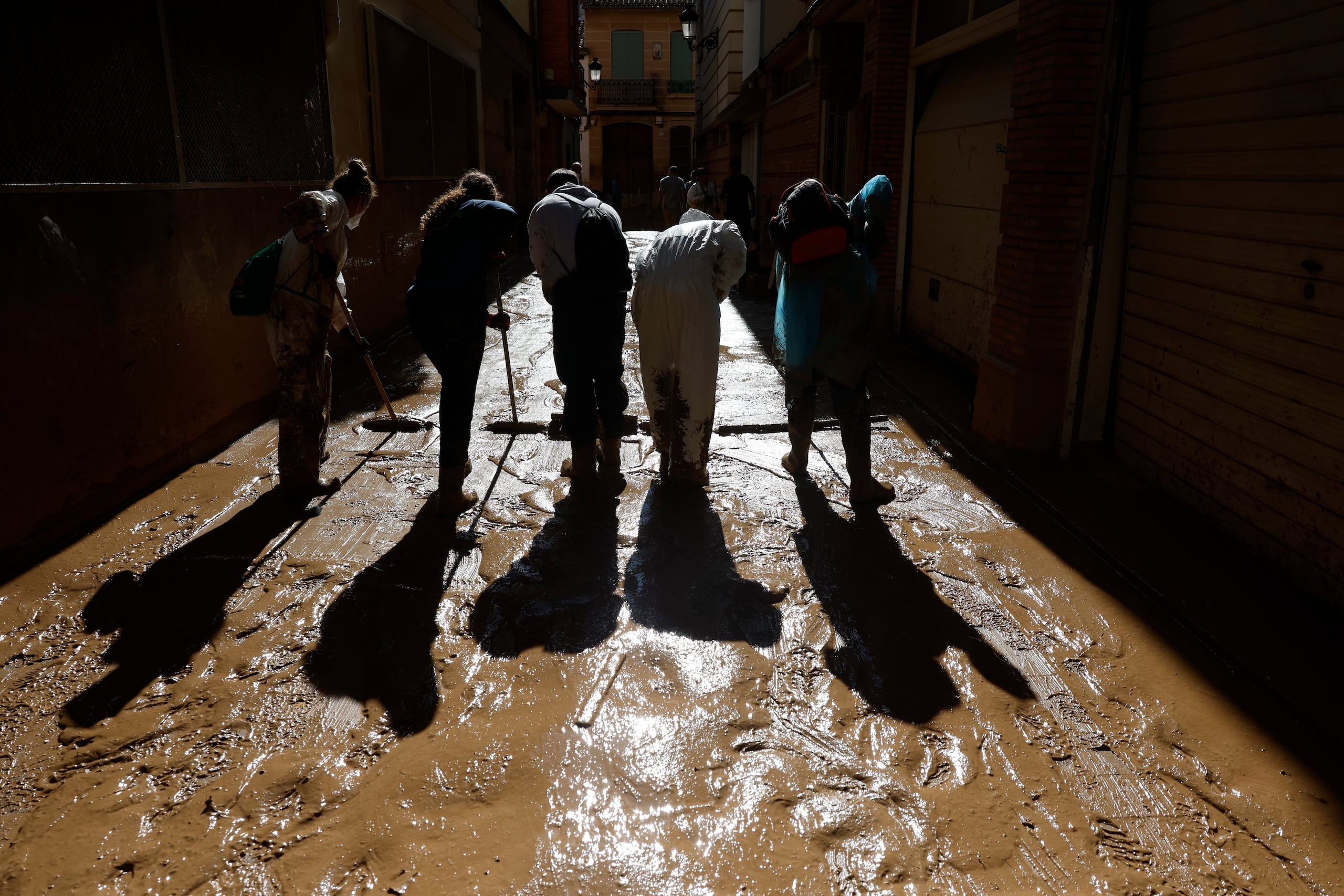 Voluntarios limpian este domingo el barro de una calle de la localidad española de Paiporta, una de las más perjudicadas por las lluvias torrenciales de la provincia mediterránea de Valencia.