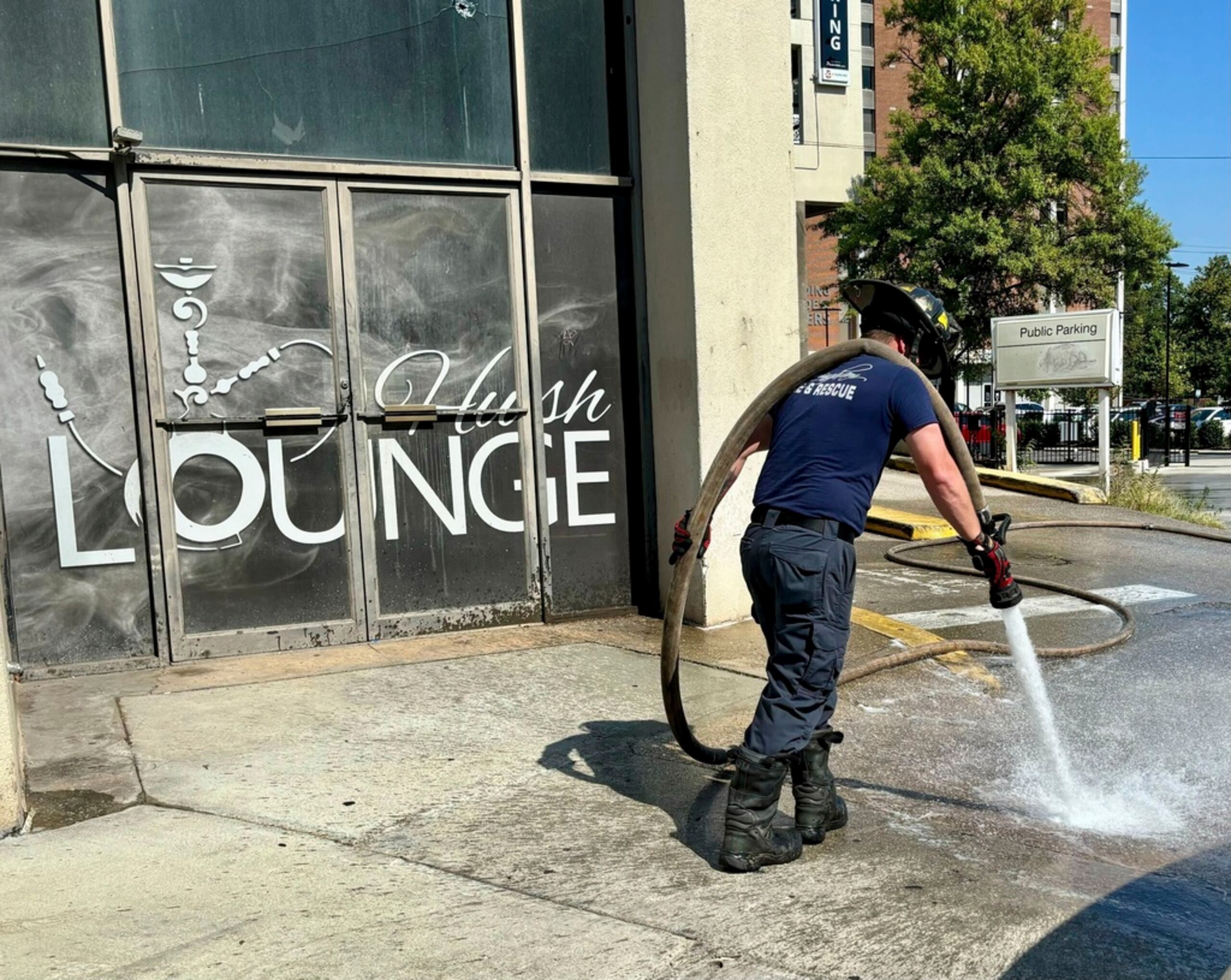 Un bombero limpia manchas de sangre de la acera frente al club nocturno Hush en Birmingham, Alabama, el 22 de septiembre de 2024, después de que ocurriera un tiroteo masivo.