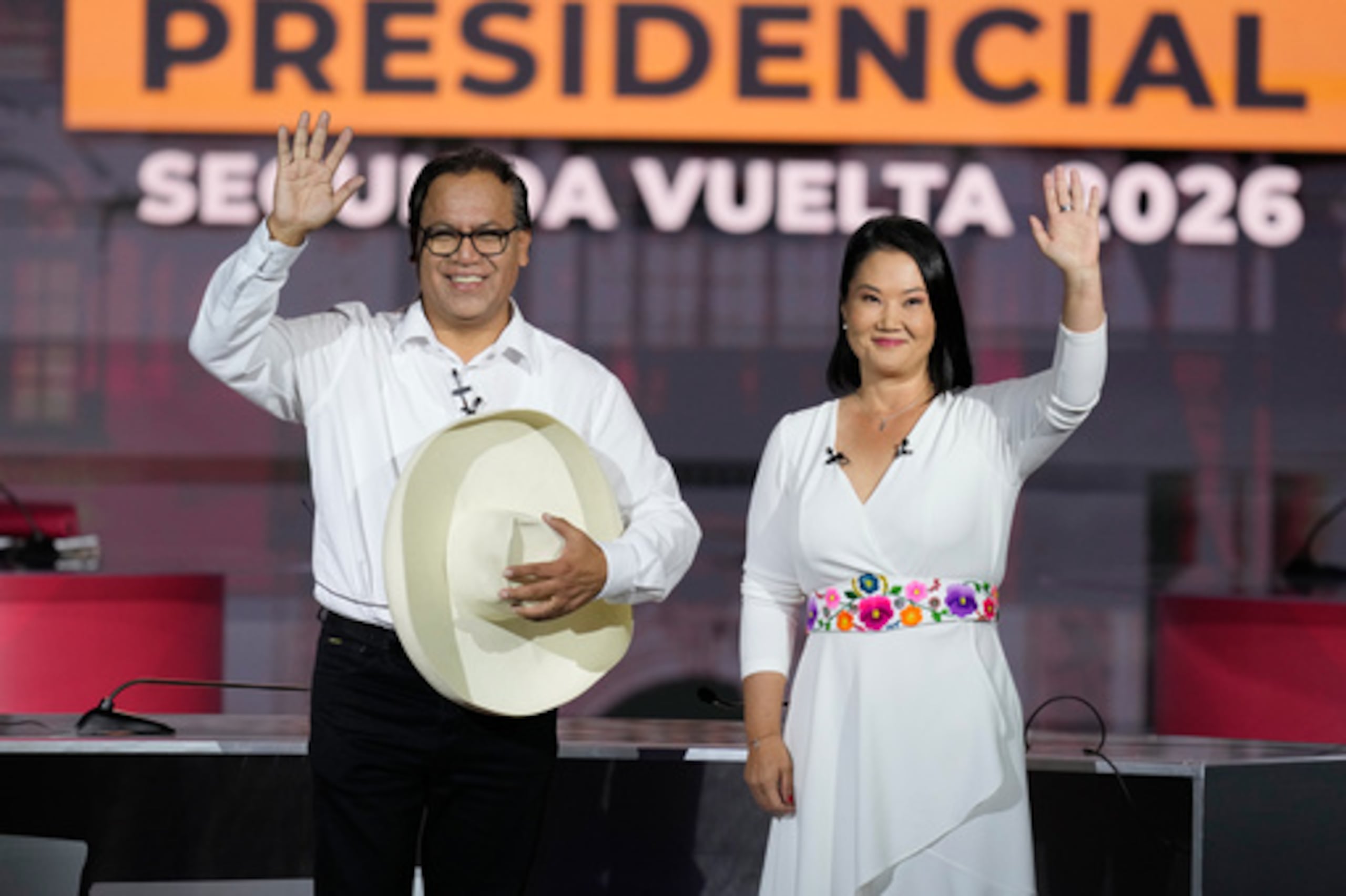 La candidata presidencial Keiko Fujimori, del partido Fuerza Popular, y su rival Roberto Sánchez, del partido Juntos por el Perú, se saludan con la mano durante un debate presidencial celebrado en Lima, Perú, el domingo 31 de mayo de 2026. (Foto AP/Martín Mejía)