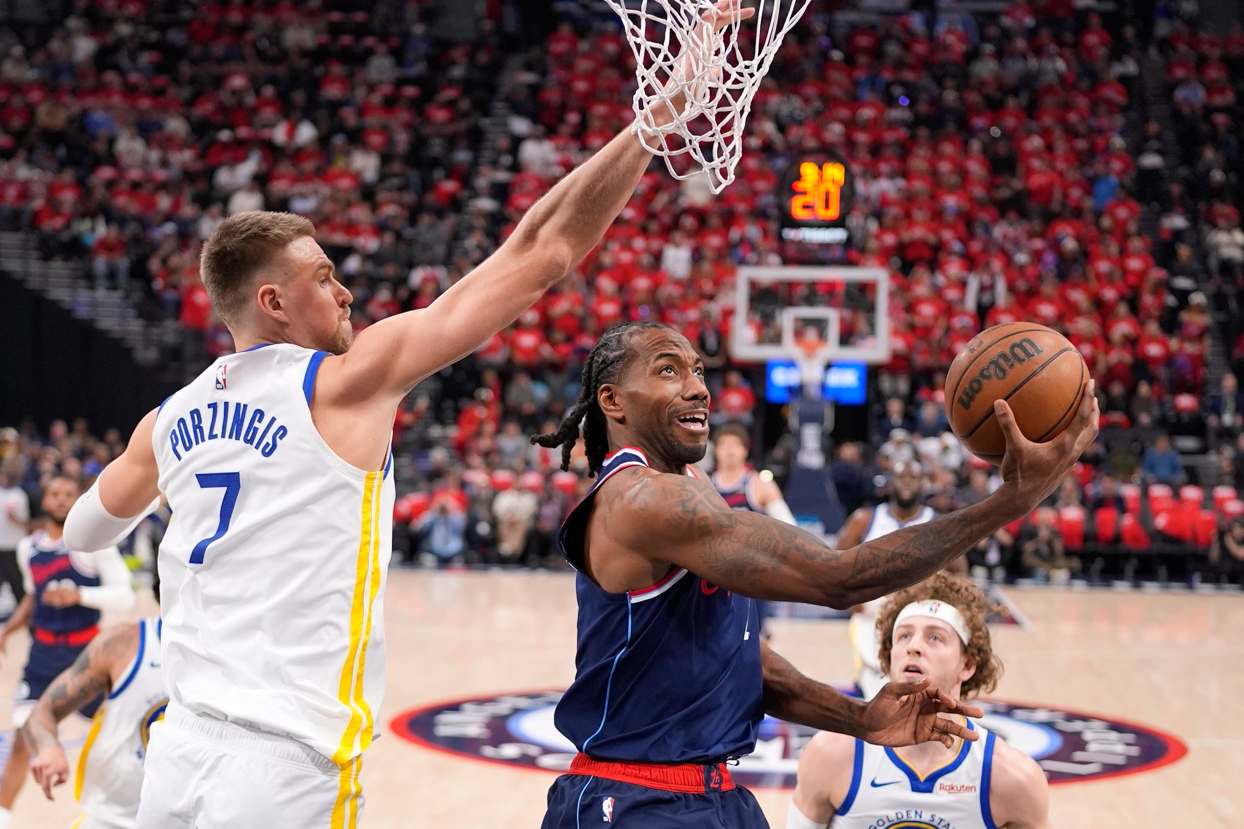 Kawhi Leonard, al centro, tira al canasto ante la defensa de Kristaps Porzingis durante su tiempo como jugador de los Clippers.
